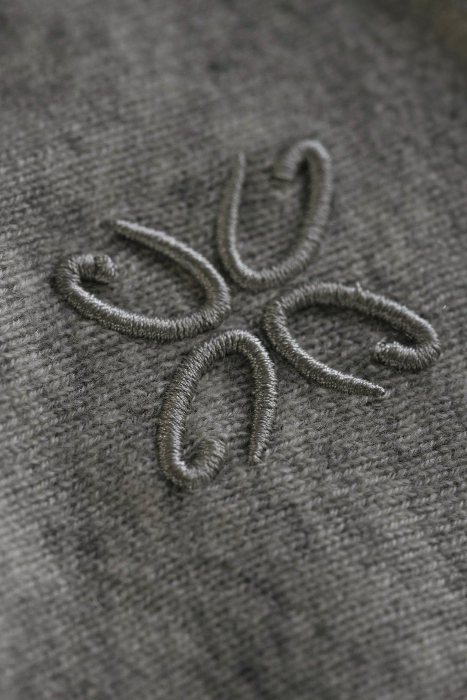 Embroidered design on a gray fabric surface