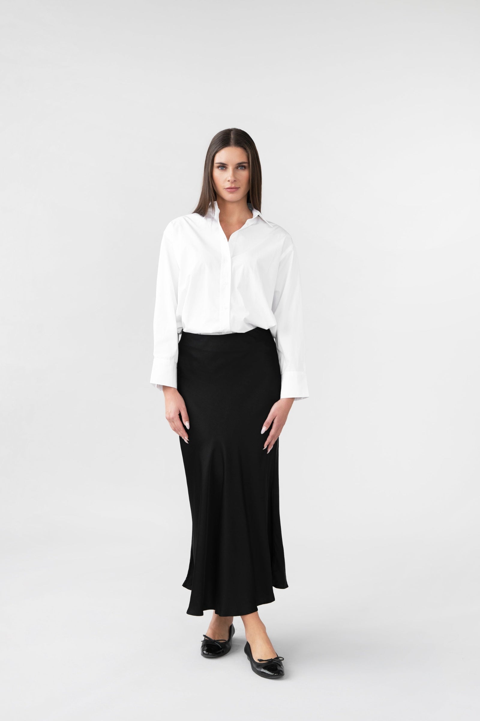 Woman wearing a white shirt and black skirt on a white background