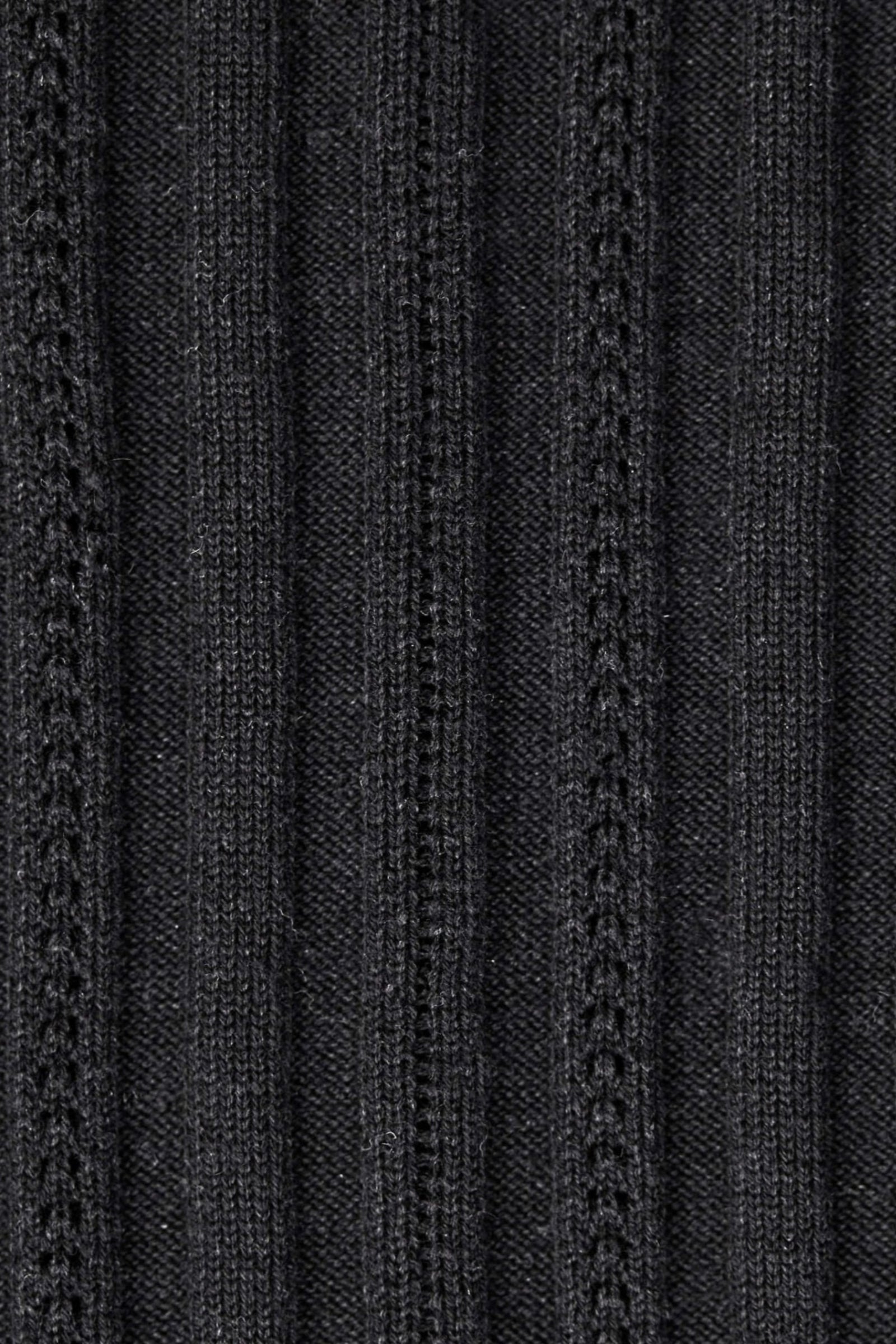 Texture detail of Cyme Copenhagen's sustainable black knit fabric, showcasing the quality and intricate patterns that exemplify the brand's commitment to top fashion and Danish designer craftsmanship in women's clothing.