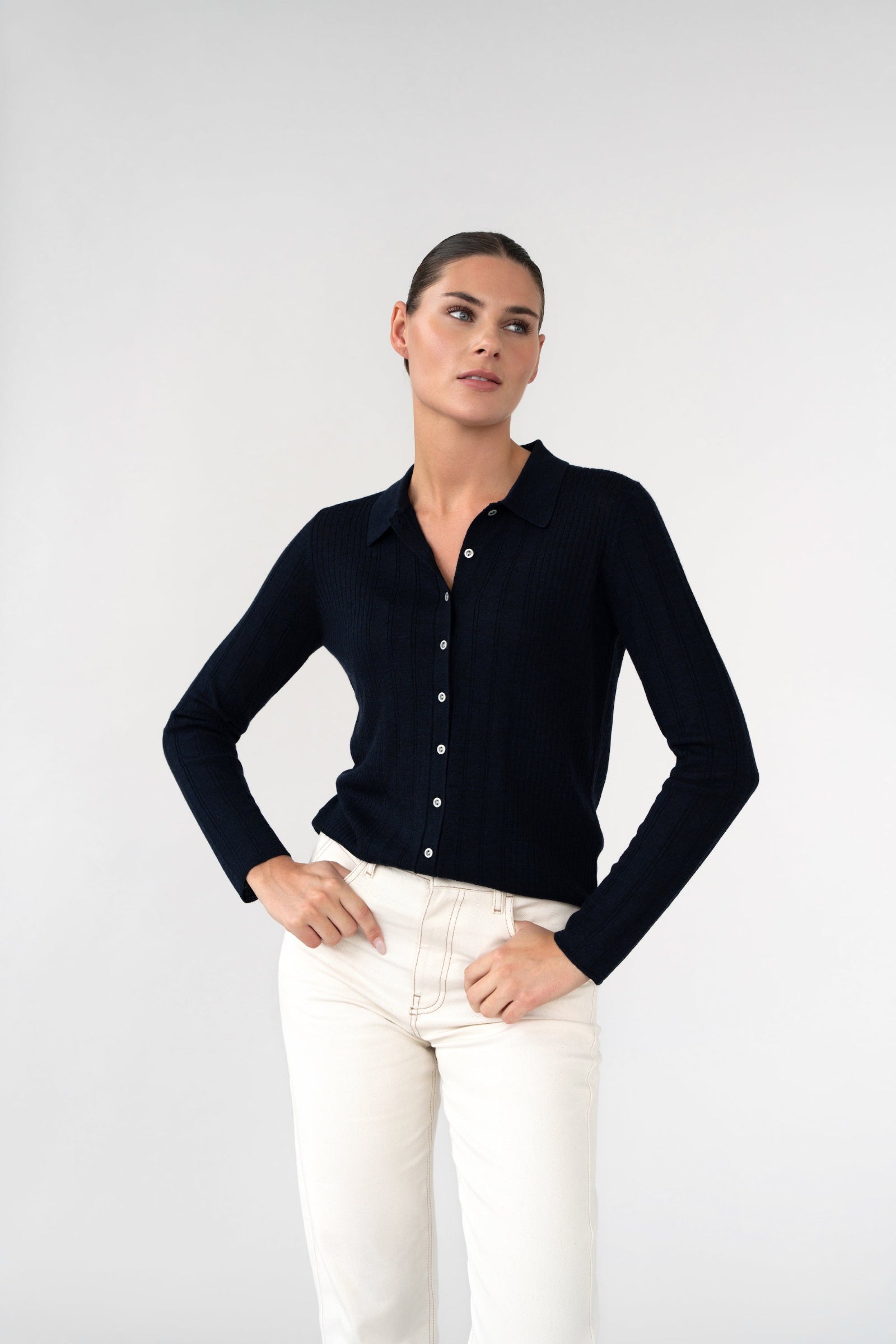 On-model three-quarter view of ribbed knit collared cardigan, navy, button front, studio.