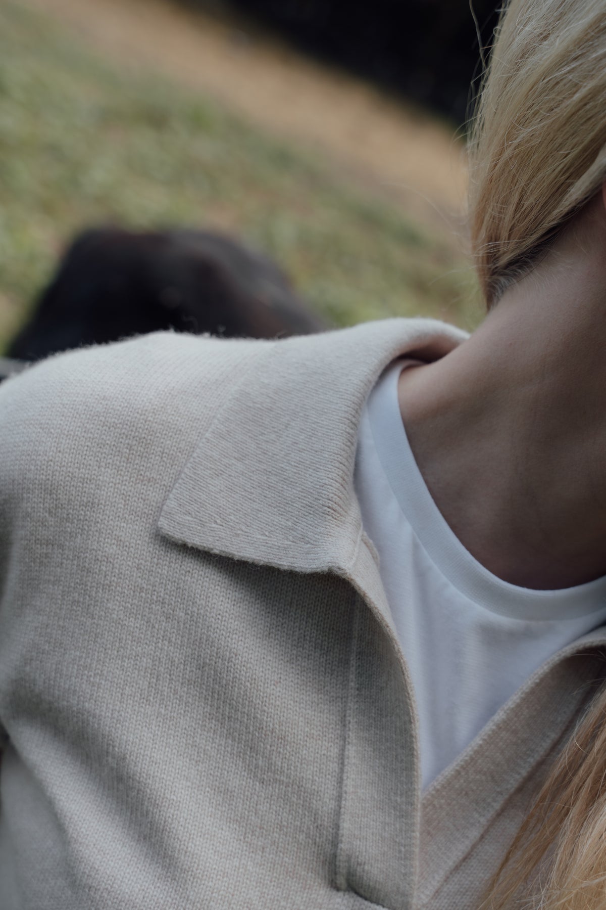 Close-up of the beige Cashmere-Merino Polo Jumper's open collar and knit texture.