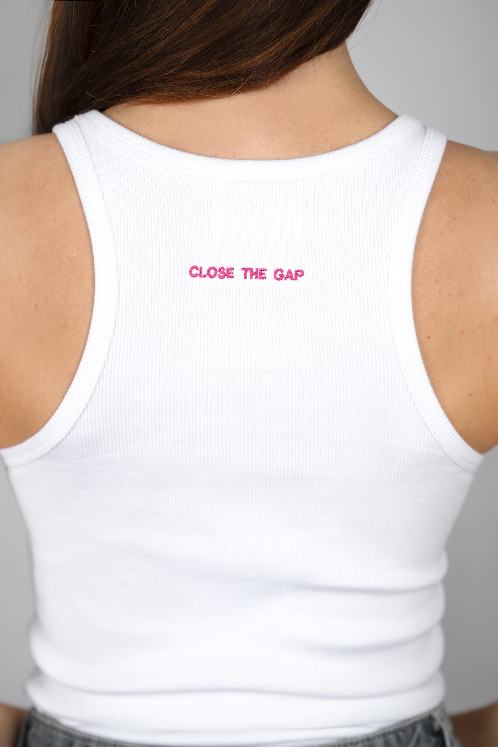 White tank top with 'CLOSE THE GAP' text on a plain background