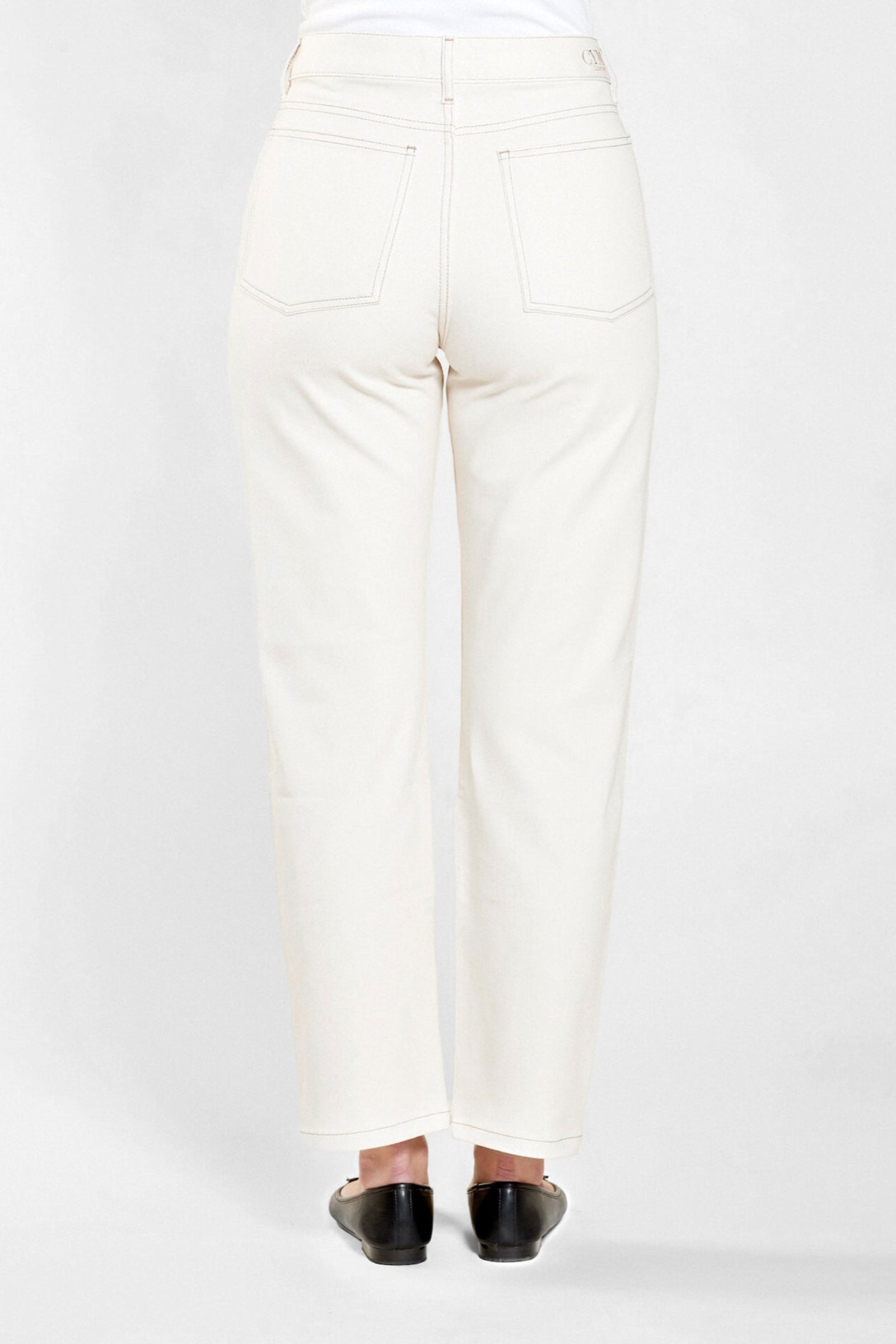 Rear view of Cyme Copenhagen's cream denim trousers, featuring a clean and classic design with signature branding on the waistband, showcasing the sustainable and chic Danish fashion ethos.