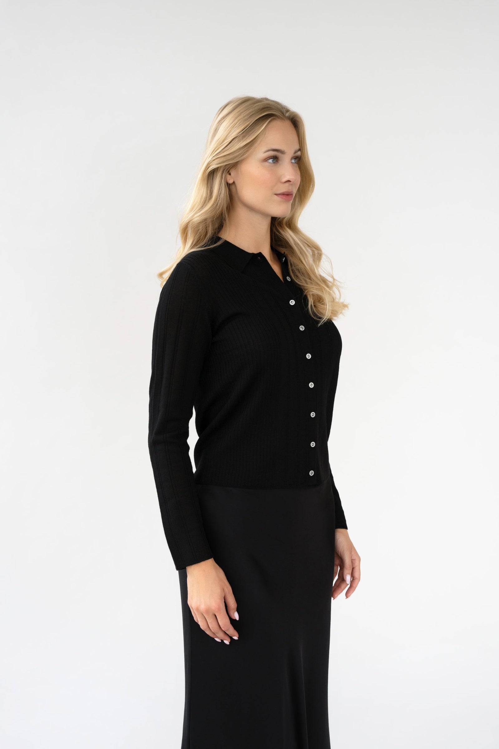 On-model side view of ribbed knit collared cardigan, black, button front, studio.
