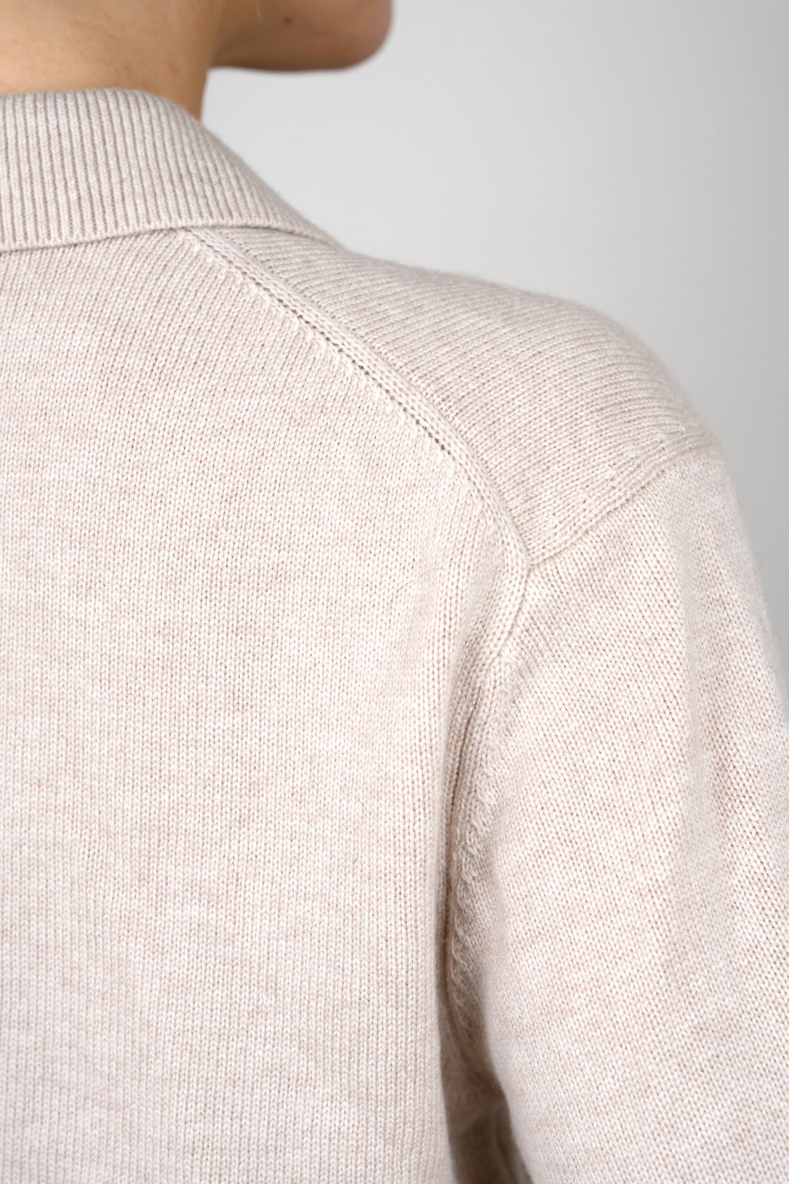 Close-up detail of the CYME Cashmere-Merino Polo Jumper in beige, highlighting the ribbed collar and shoulder seam in a soft cashmere-merino knit.