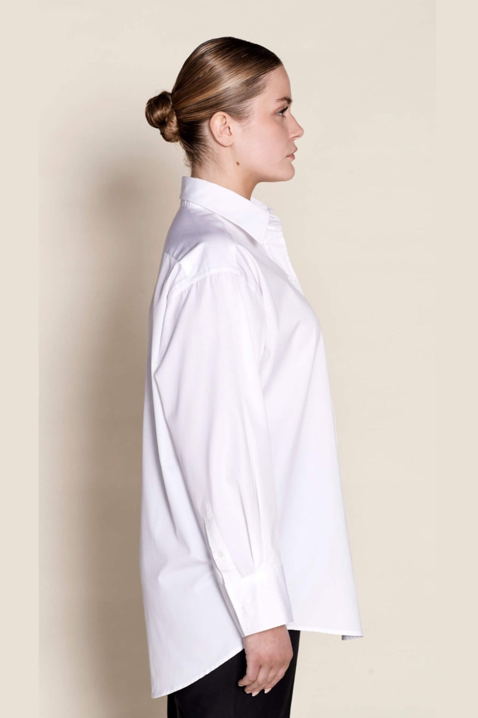 Side profile of a Cyme Copenhagen classic white shirt, displaying the relaxed fit and elegant tailoring that make it a timeless wardrobe essential for sustainable Scandinavian style.