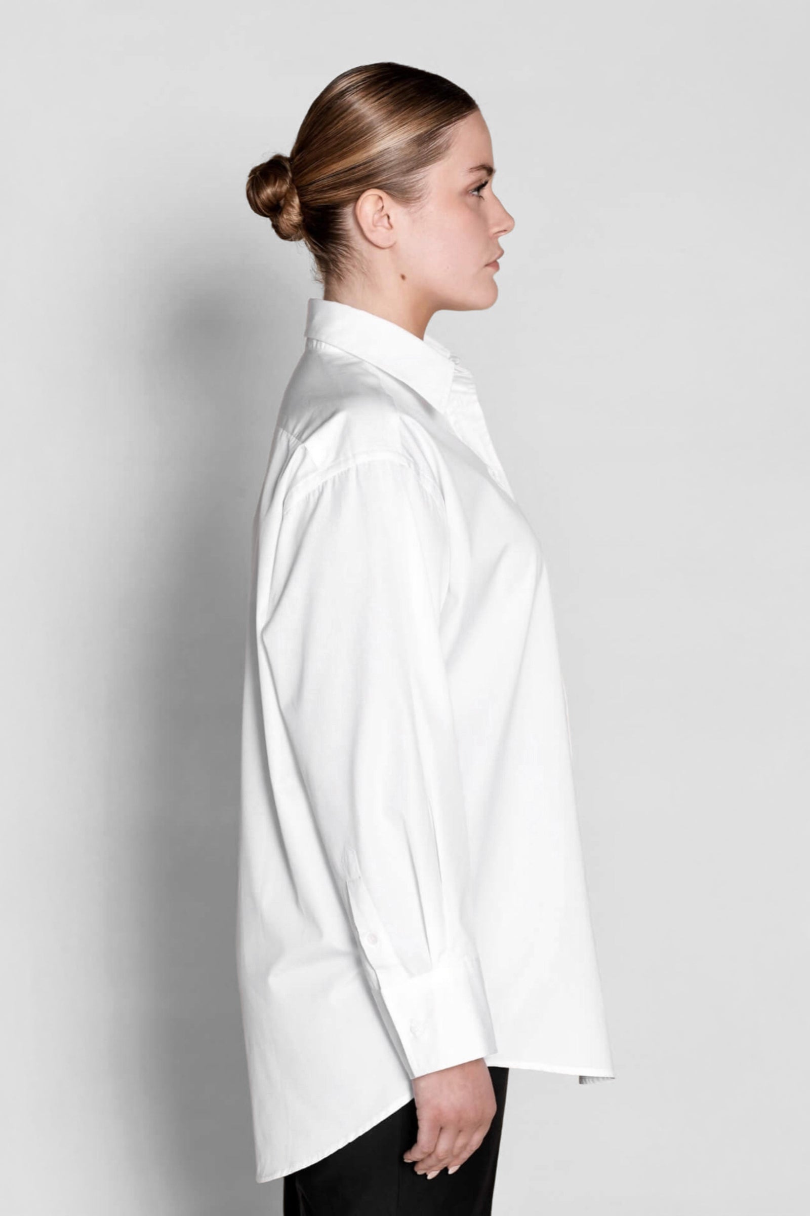 Side profile of a Cyme Copenhagen classic white shirt, displaying the relaxed fit and elegant tailoring that make it a timeless wardrobe essential for sustainable Scandinavian style.