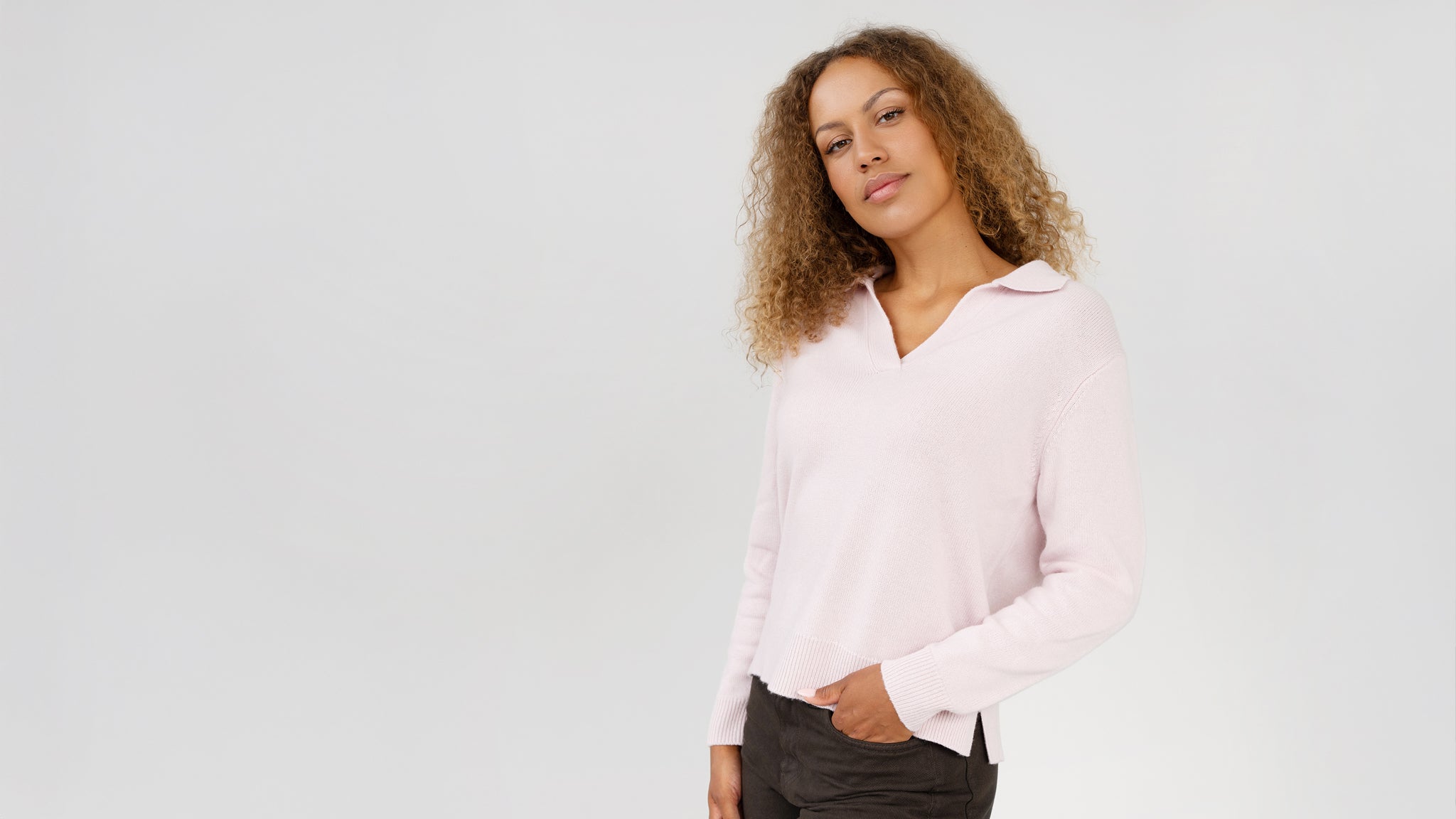 Woman wearing a light pink blouse against a plain background