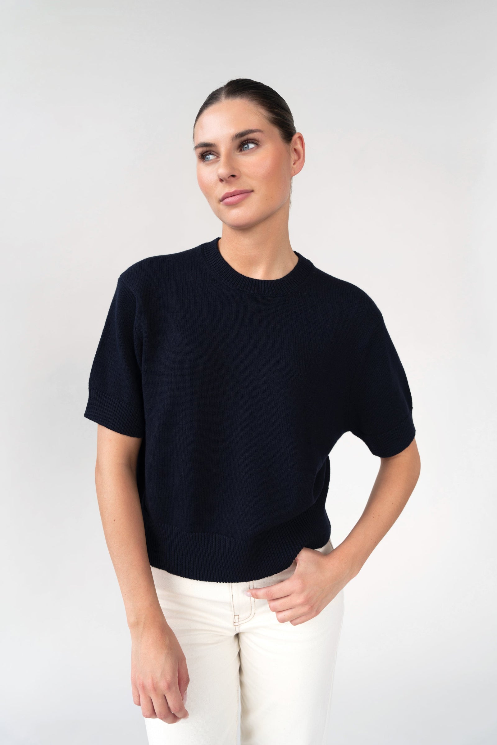 On-model front view of short-sleeve knit top, navy, crew neck, studio.