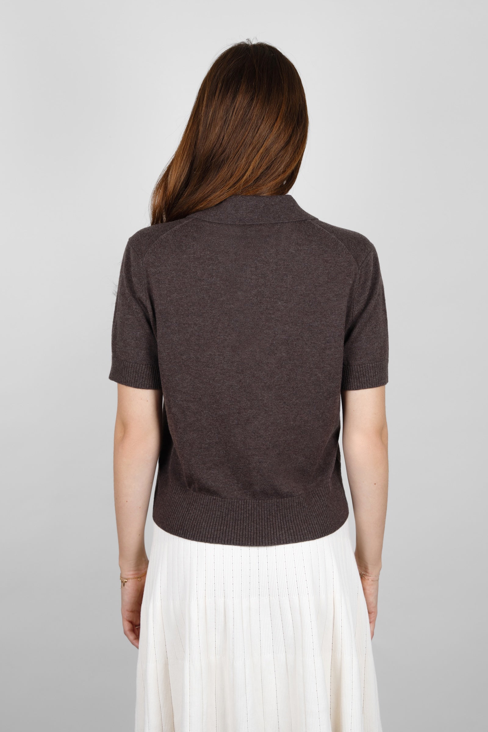 Back view of the CYME Short Sleeve Polo Shirt in dark brown, showing the collar, short sleeves and ribbed hem. Knitted in a soft, fine fabric for a relaxed, timeless fit.