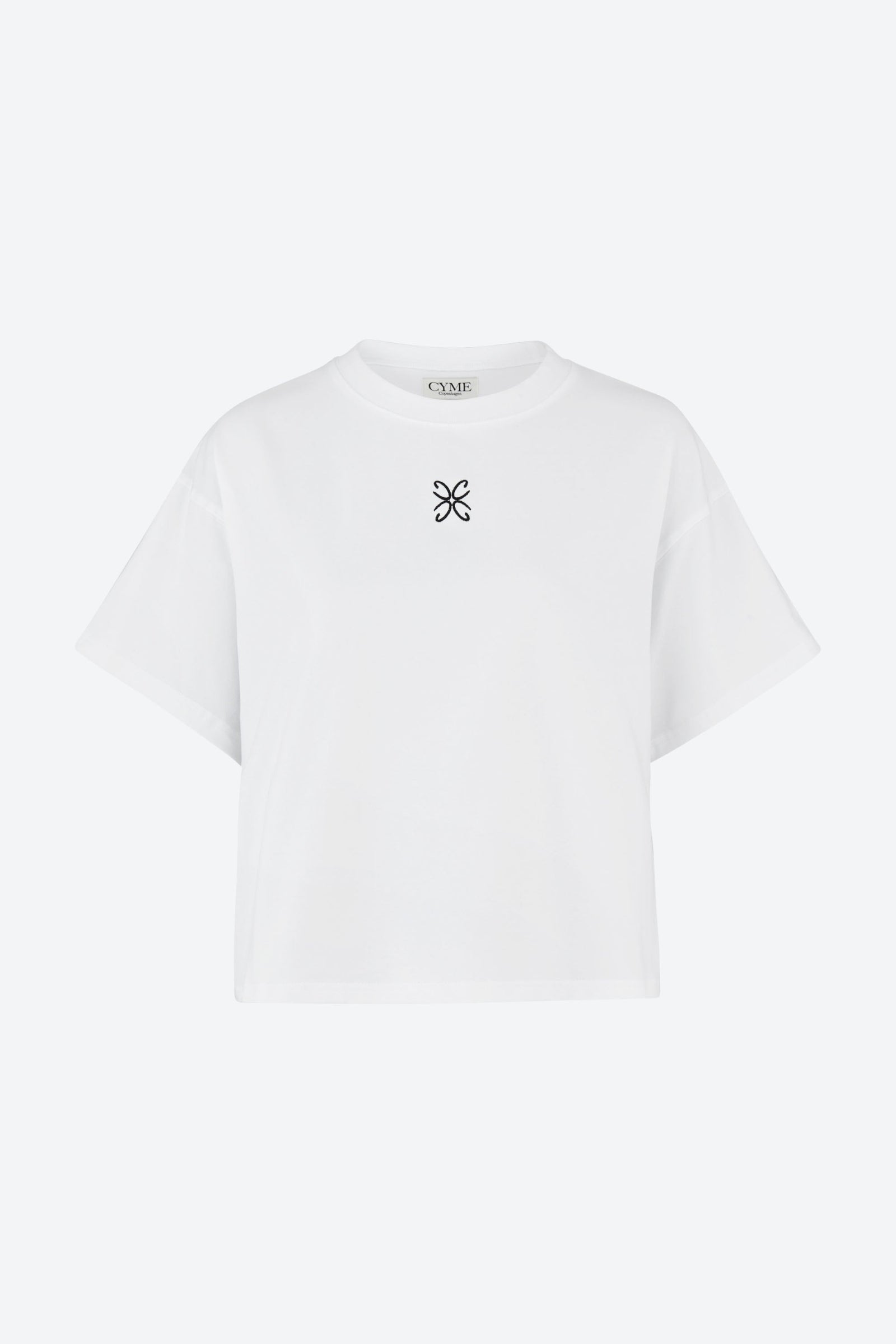 Hvid oversized T-shirt fra CYME Copenhagen i økologisk bomuld med sort broderet CYME-logo centreret på brystet.