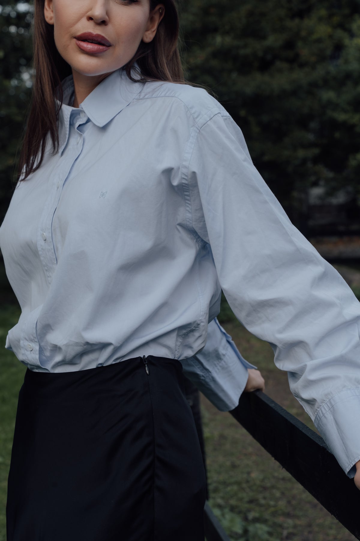 Light blue Cyme Supima Shirt worn with black trousers, showing its collar and long sleeves.
