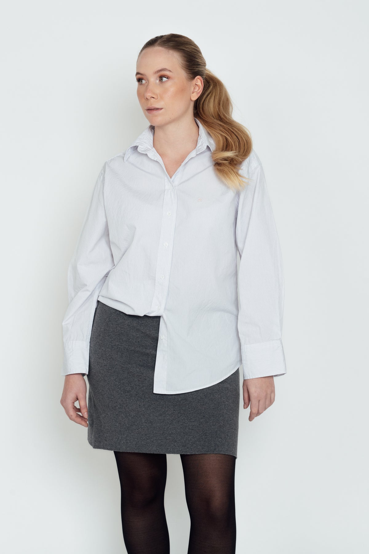 Light Blue & Pink Cyme Supima Shirt worn partly tucked into a grey skirt.