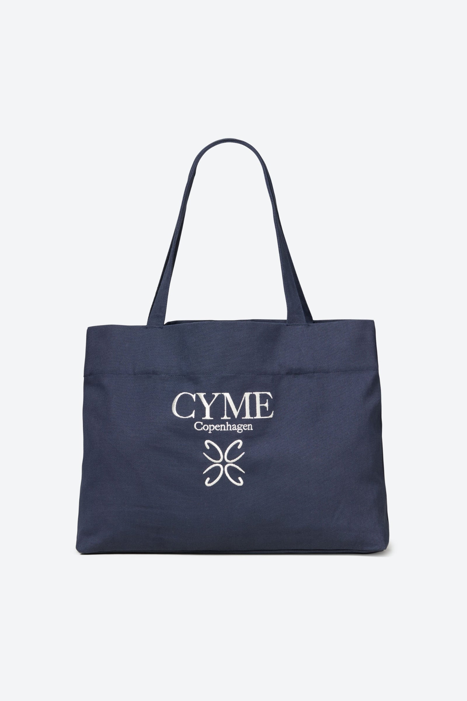 A navy blue tote bag with "CYME Copenhagen" embroidered in white thread on the front.