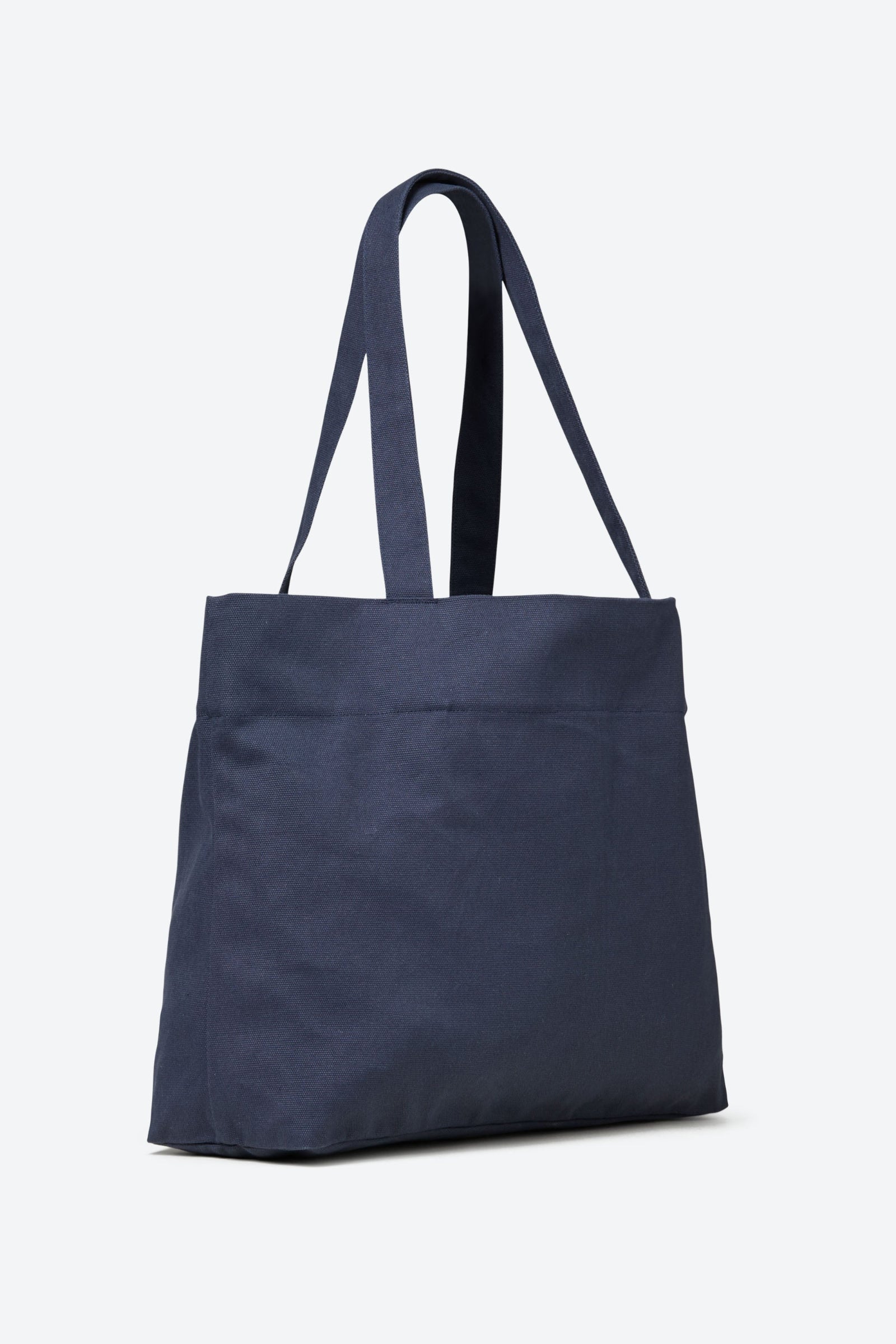 Side view of the navy-colored CYME Copenhagen tote bag, highlighting its spacious interior and sturdy handle construction.