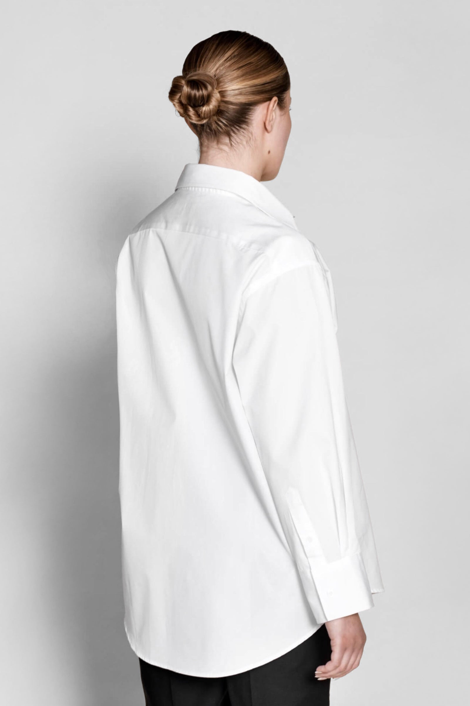 Elegant back view of a Cyme Copenhagen white cotton shirt, highlighting the meticulous design and sustainable fashion ethos of the Danish brand.