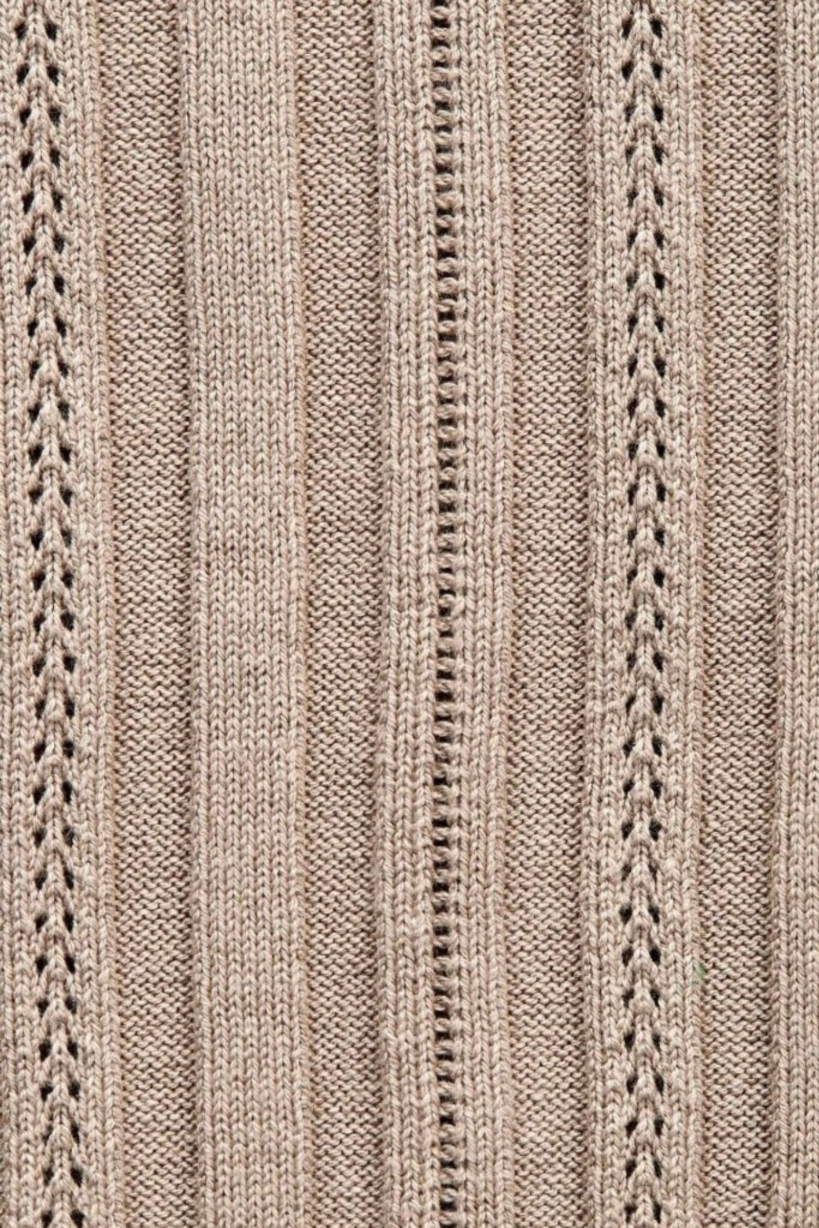 Close-up of the intricate knit pattern on a taupe garment, showcasing Cyme Copenhagen's attention to detail and craftsmanship in sustainable materials for their Danish fashion brand, specializing in women's clothing.