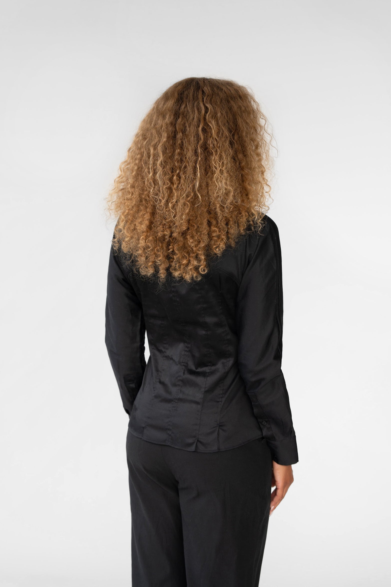 Person wearing a black outfit with a plain background