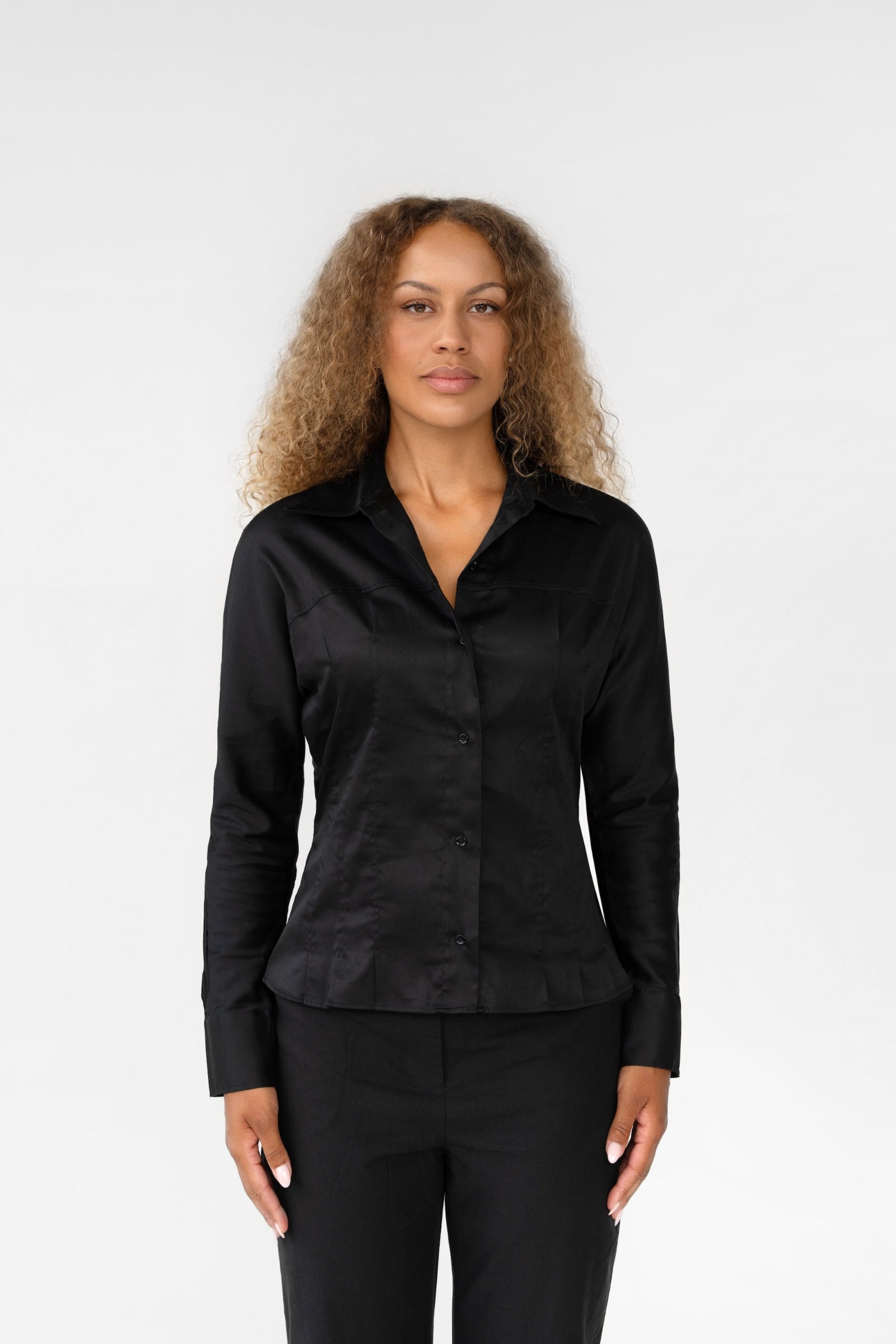 Woman wearing a black hourglass shirt against a white background