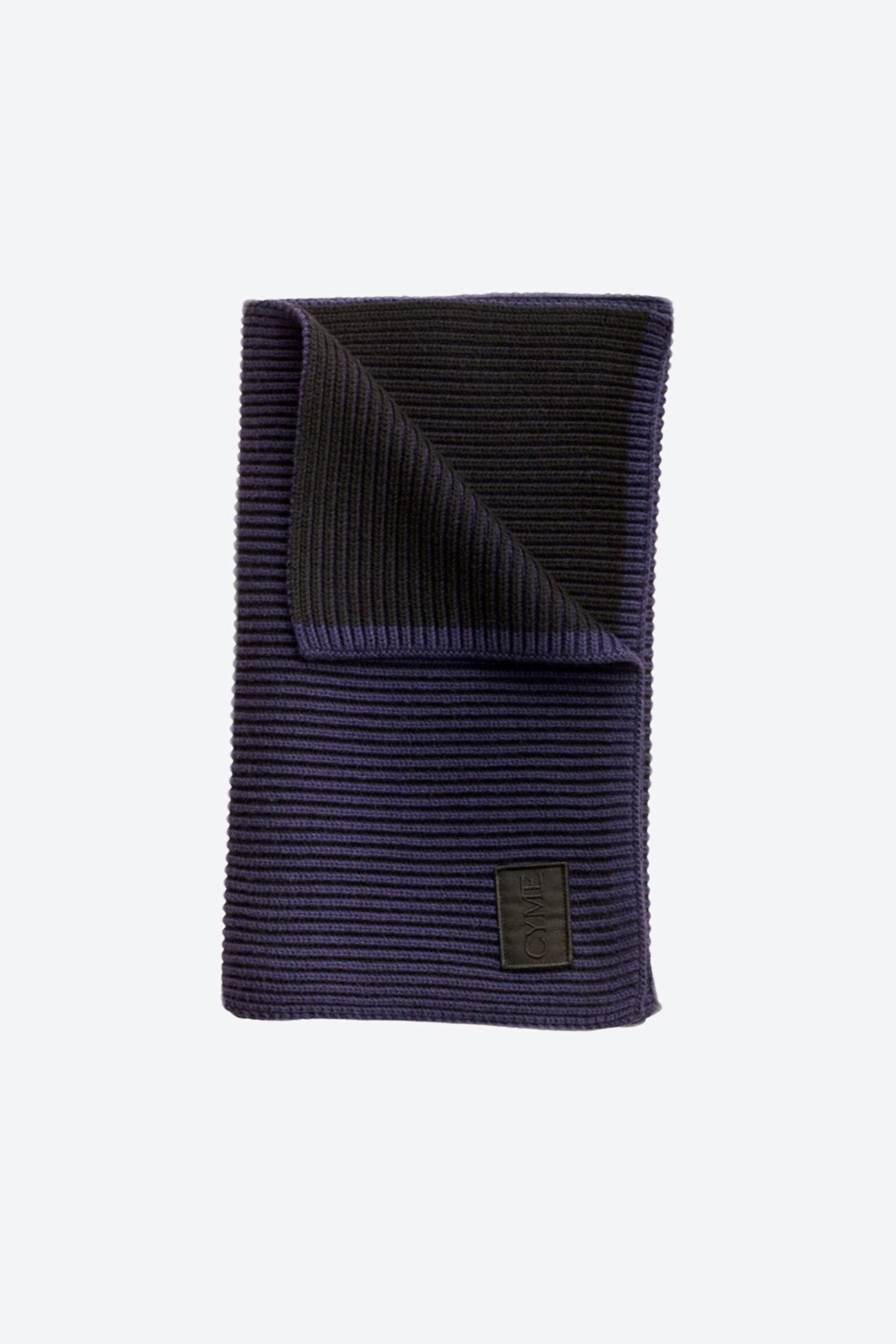 Cyme Copenhagen navy ribbed knit scarf, elegantly folded with a branded high quality patch, highlighting the brand's focus on sustainable fashion accessories in Denmark.