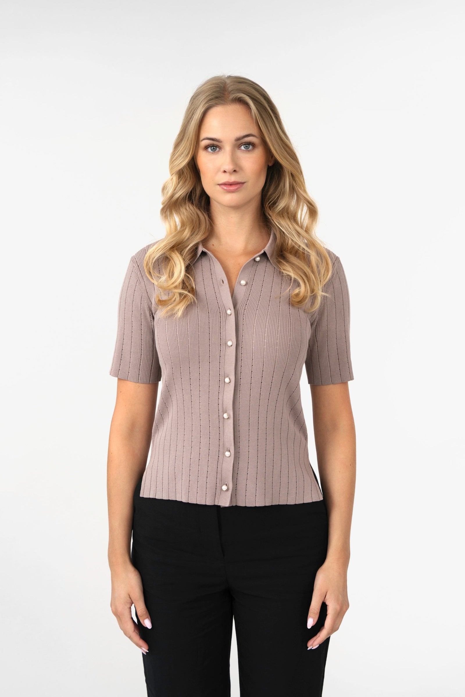 Woman wearing a brown ribbed blouse with short sleeves on a white background