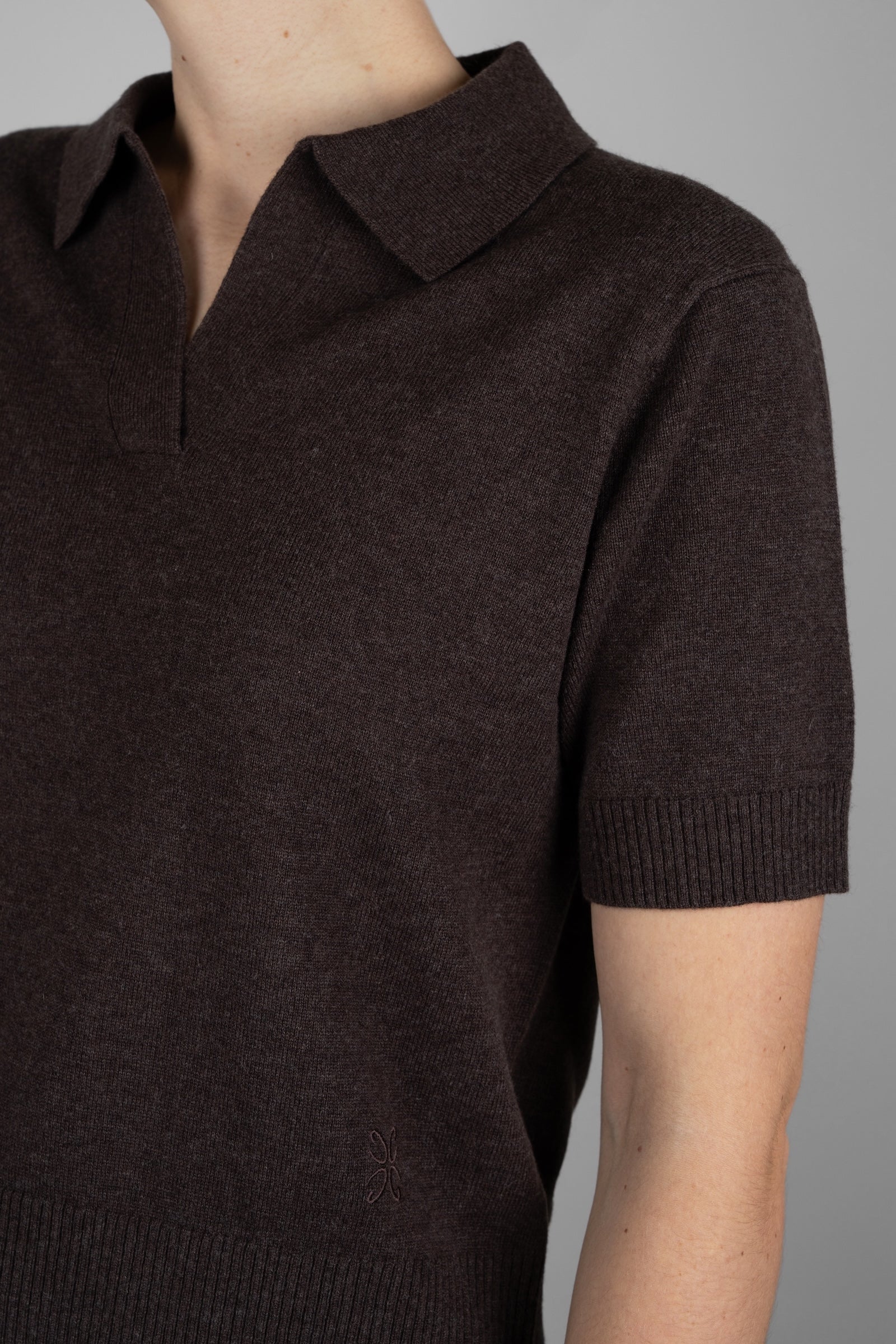 Brown short-sleeve knit polo shirt on a neutral background