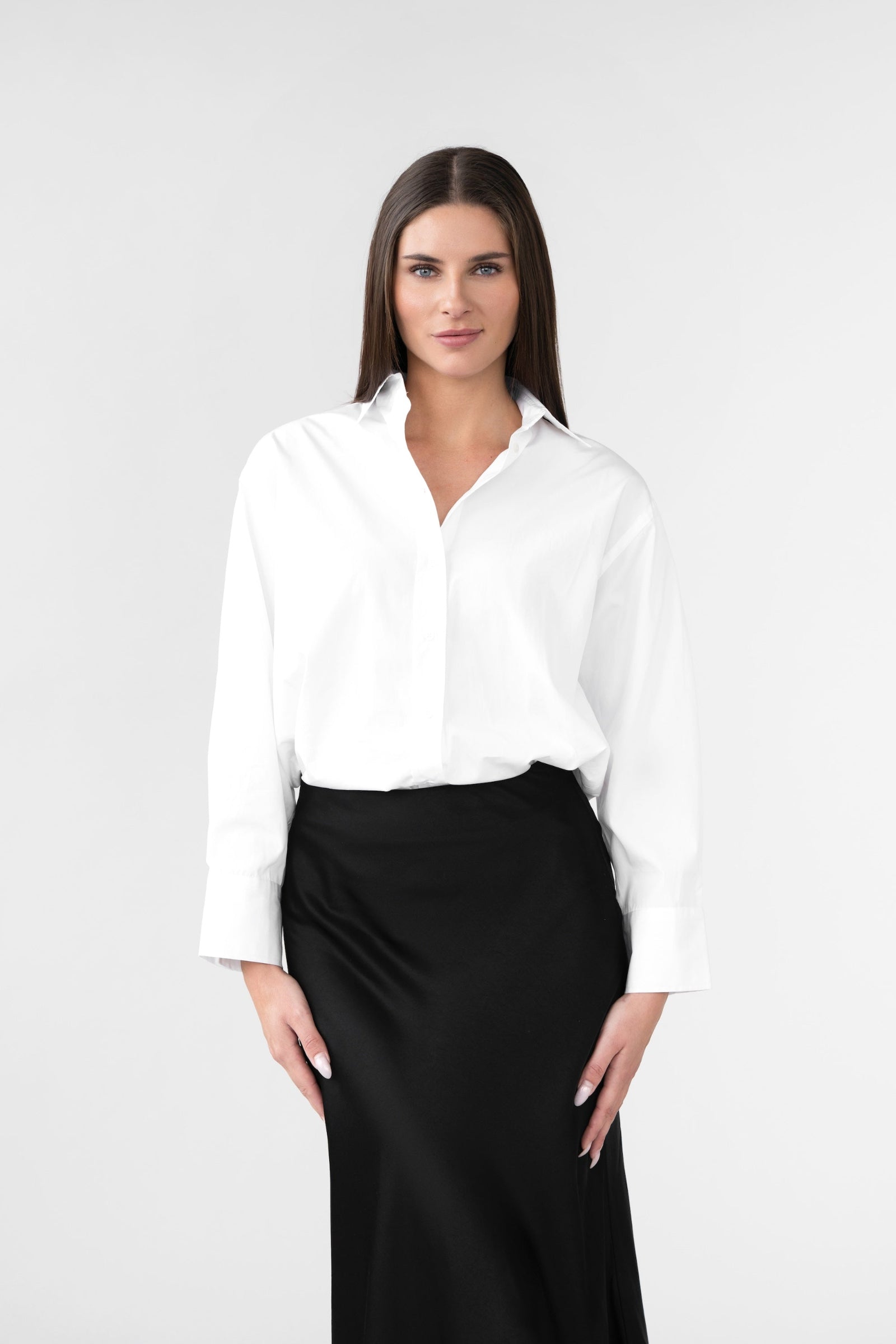 Woman wearing a white blouse and black skirt on a white background