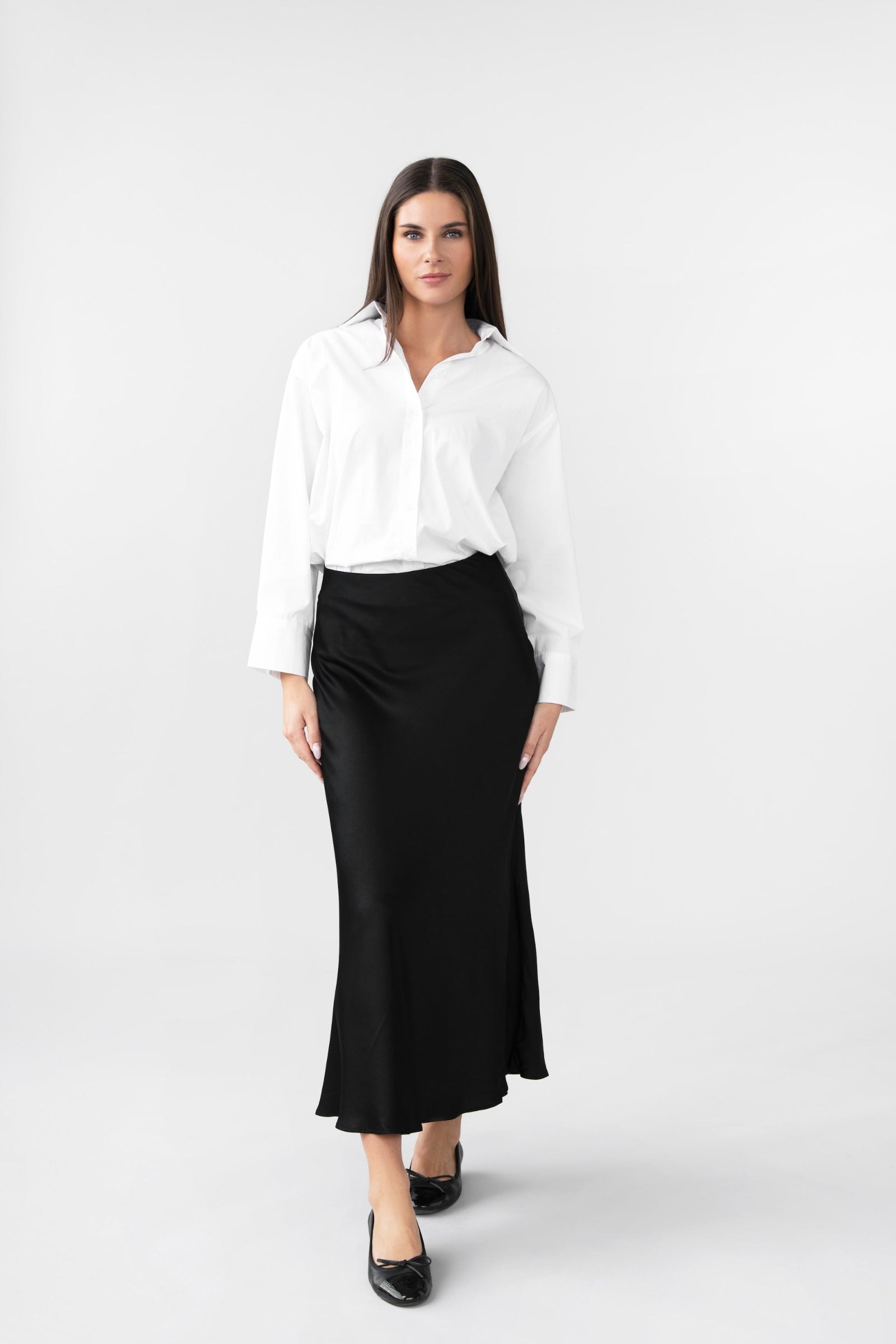 Woman wearing a white shirt and black skirt on a white background
