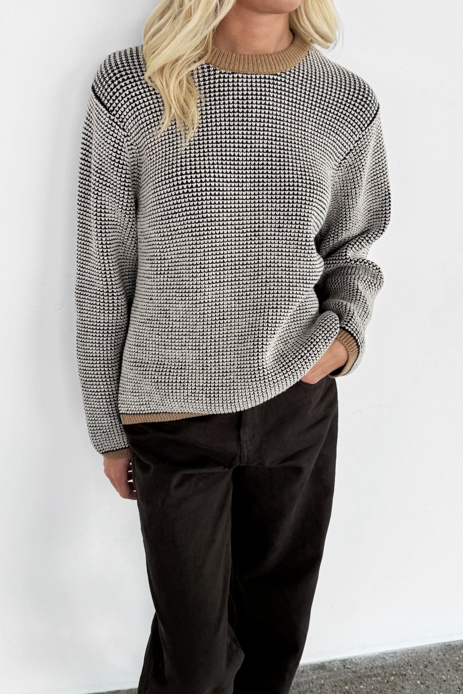 close up picture of waffleknit merino jumper in black, white and taupe.