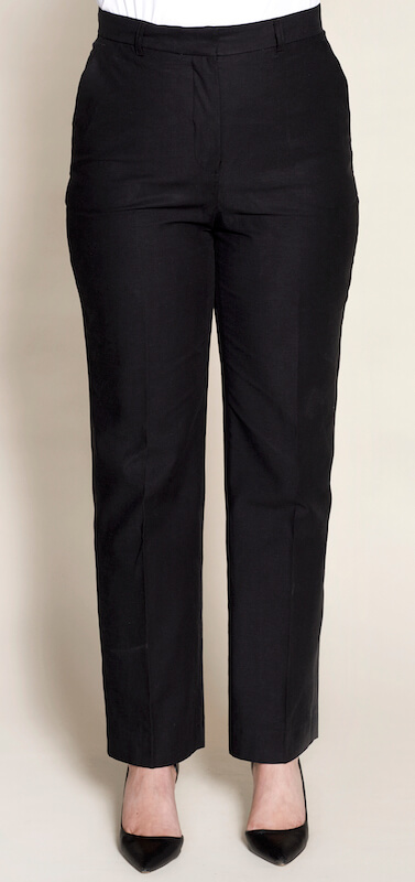 A front view of a person wearing black, tailored pants from CYME. The pants have a high waist and straight-leg fit, paired with black pointed-toe shoes.