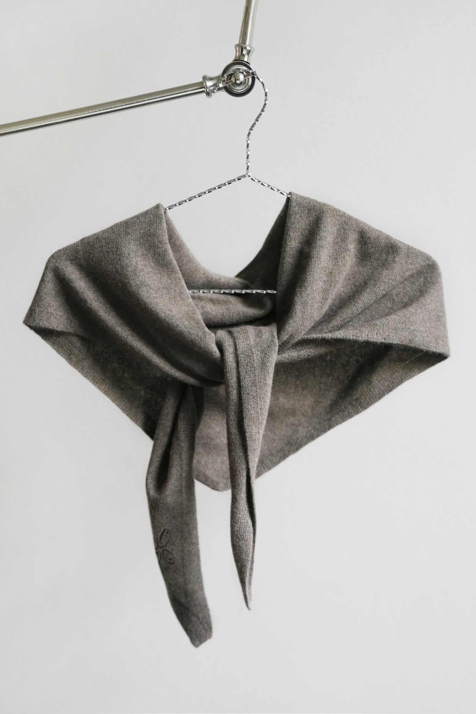 Gray scarf on a hanger against a white background