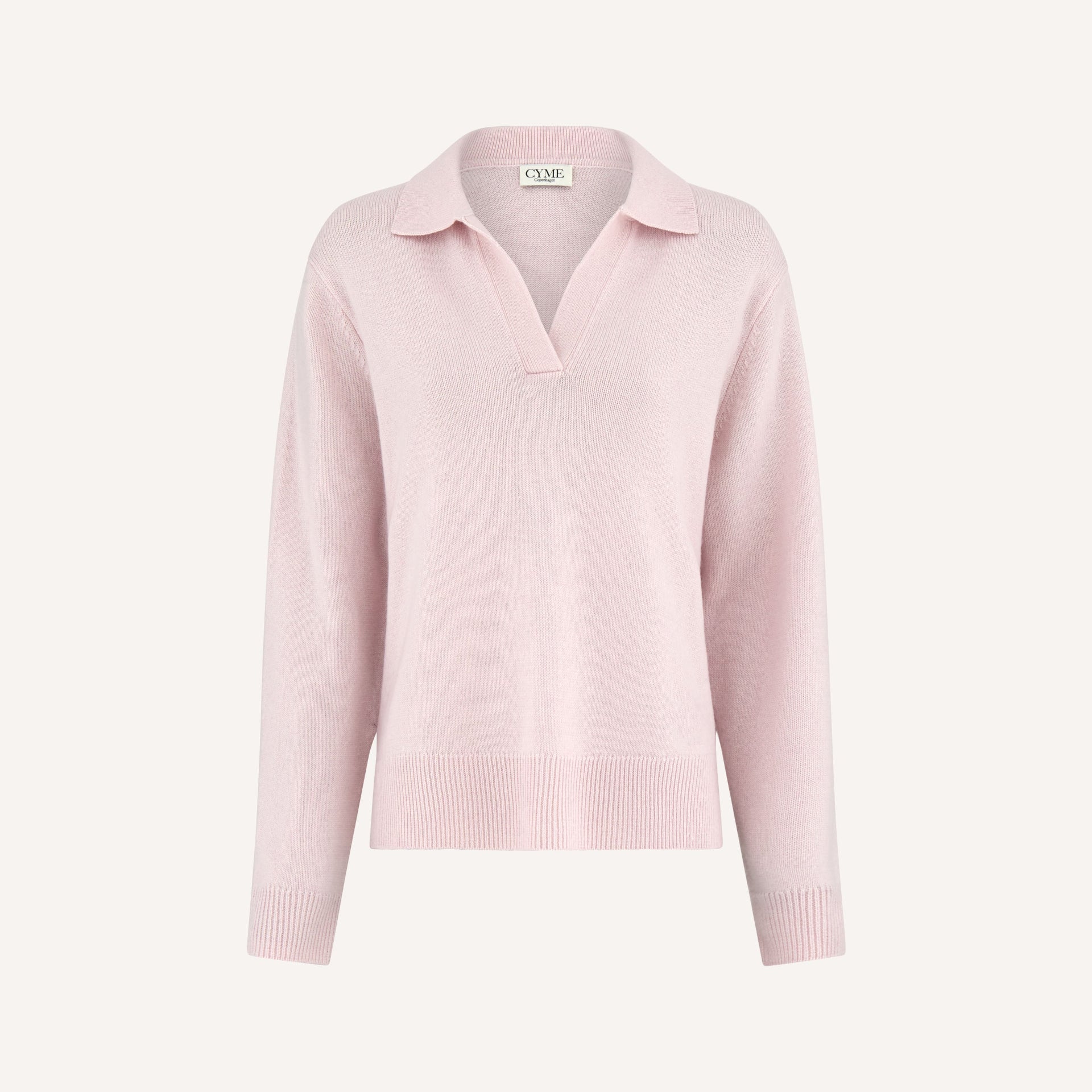 A front view of a light pink polo-style knit jumper with a deep V-neck and long sleeves.