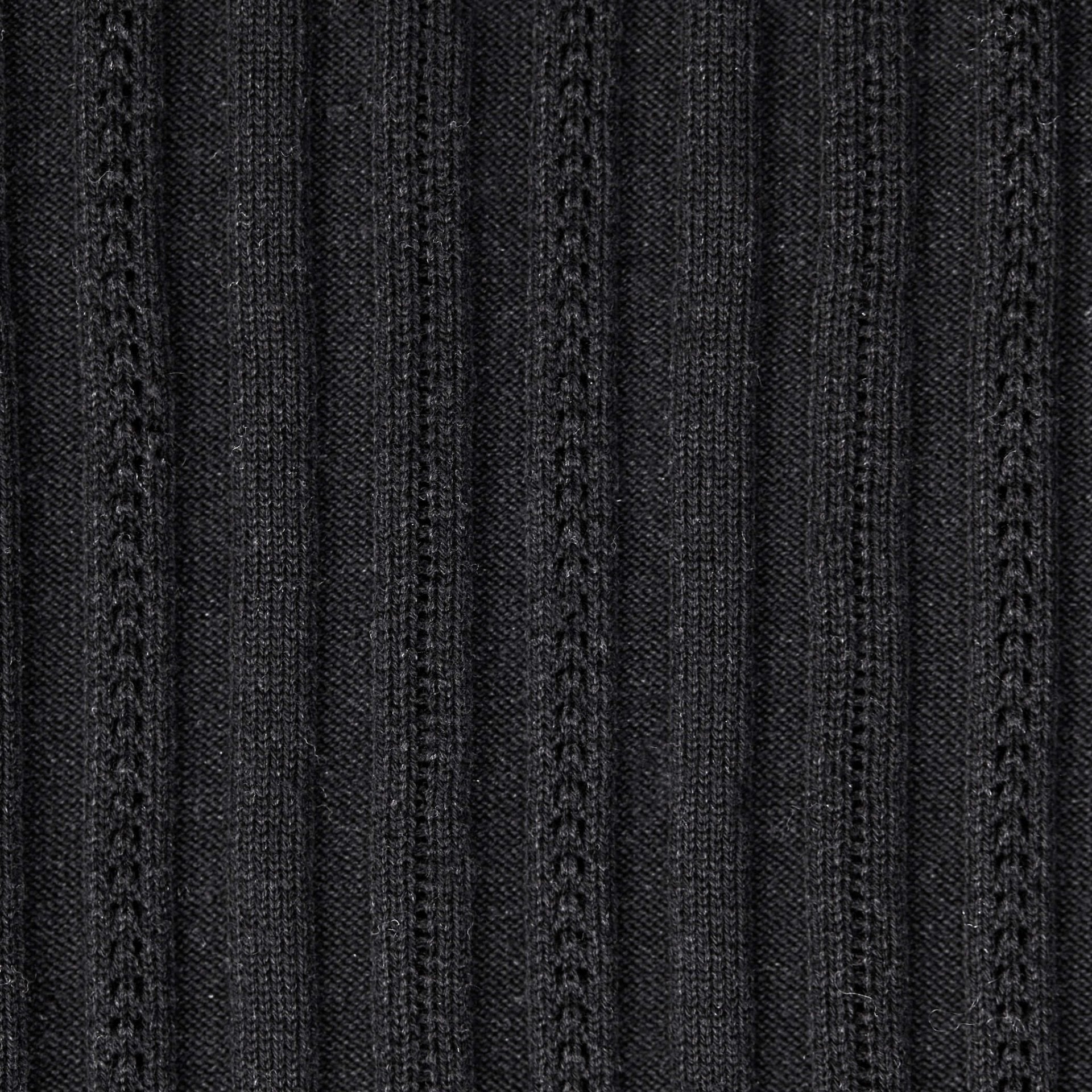 Texture detail of Cyme Copenhagen's sustainable black knit fabric, showcasing the quality and intricate patterns that exemplify the brand's commitment to top fashion and Danish designer craftsmanship in women's clothing.