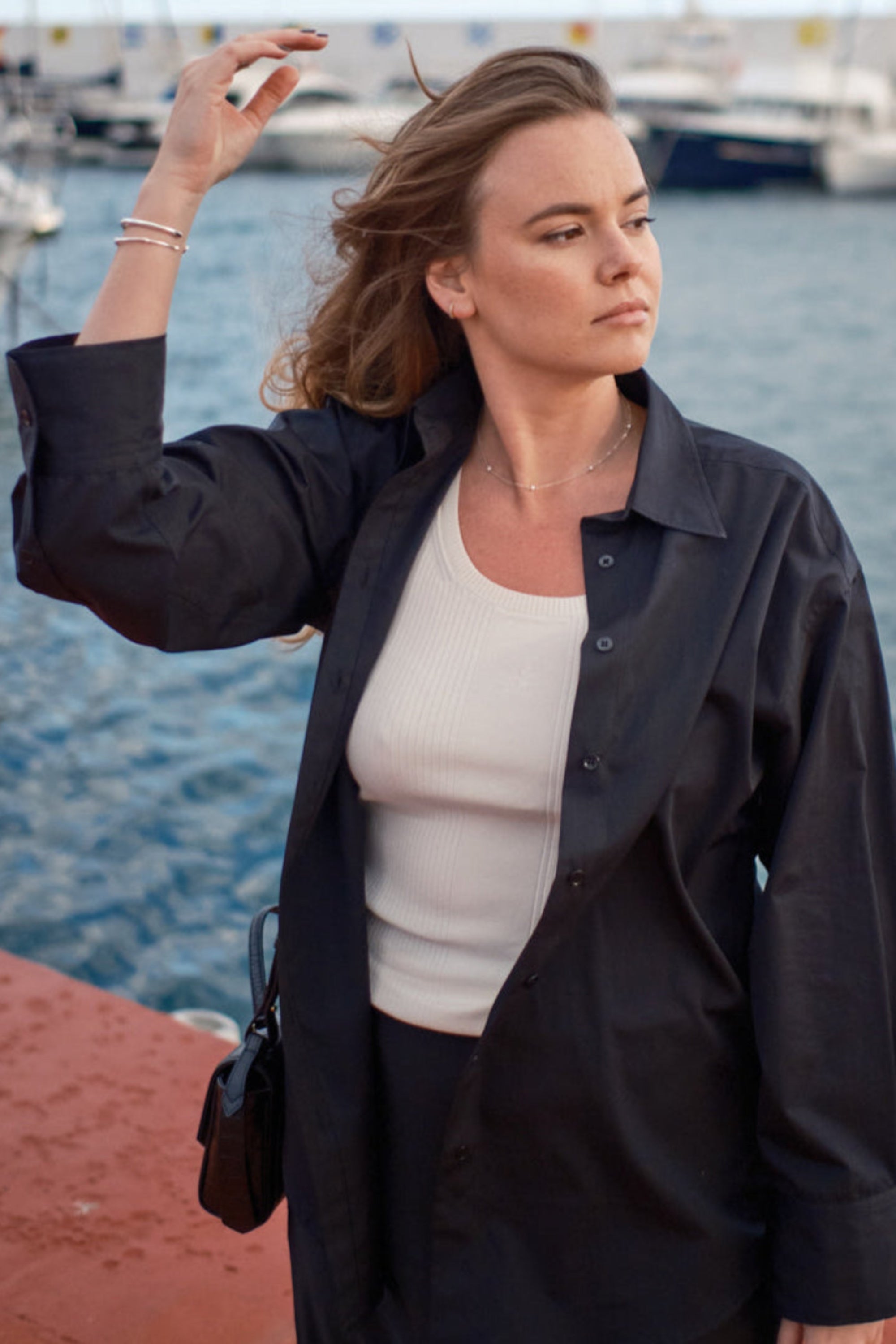 Women wearing an ivory top layered under the black supima shirt.