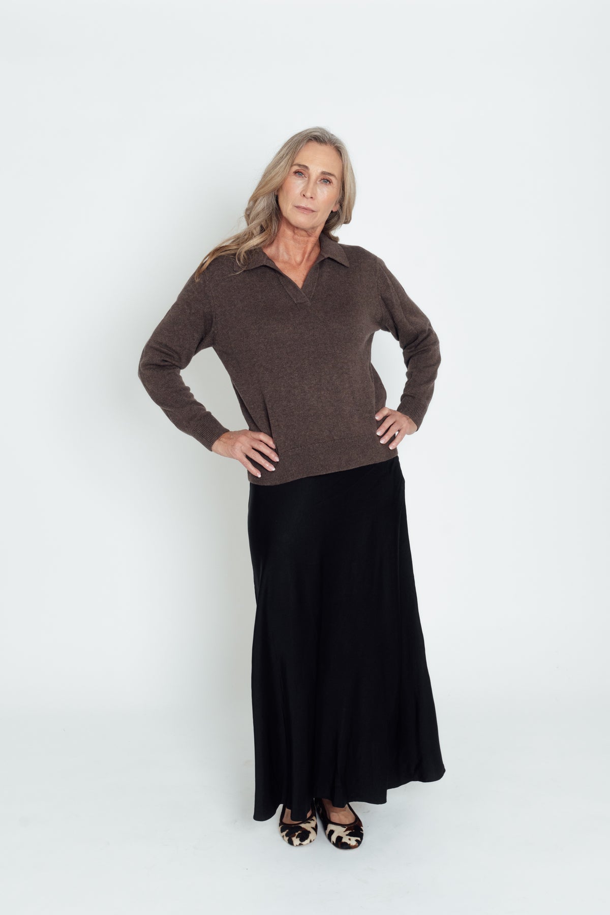 Dark brown Cashmere-Merino Polo Jumper worn with hands on hips, showing its open collar.