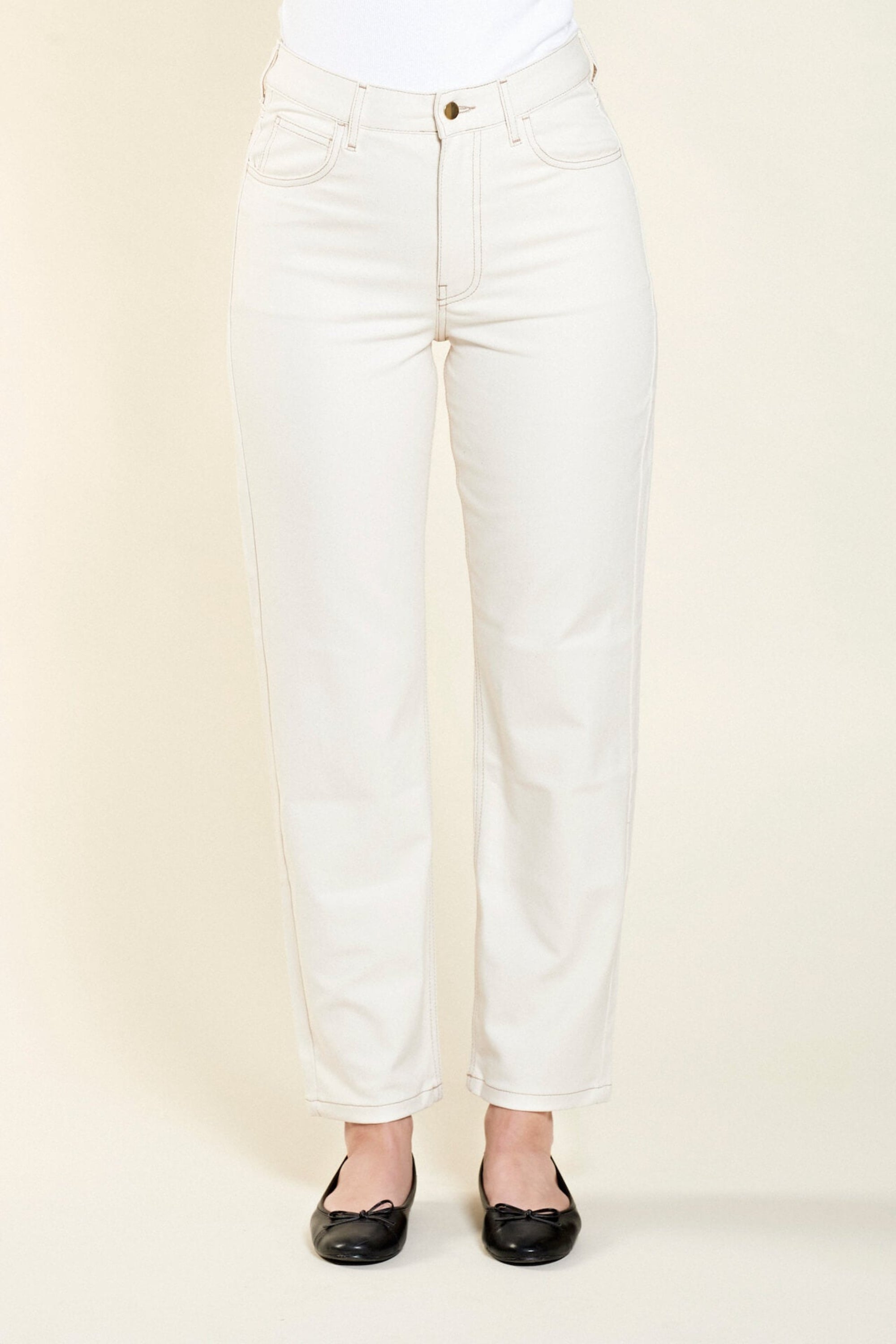 Front view of Cyme Copenhagen's classic cream denim trousers, showcasing the sophisticated cut and sustainable quality materials characteristic of the Danish designer fashion brand.