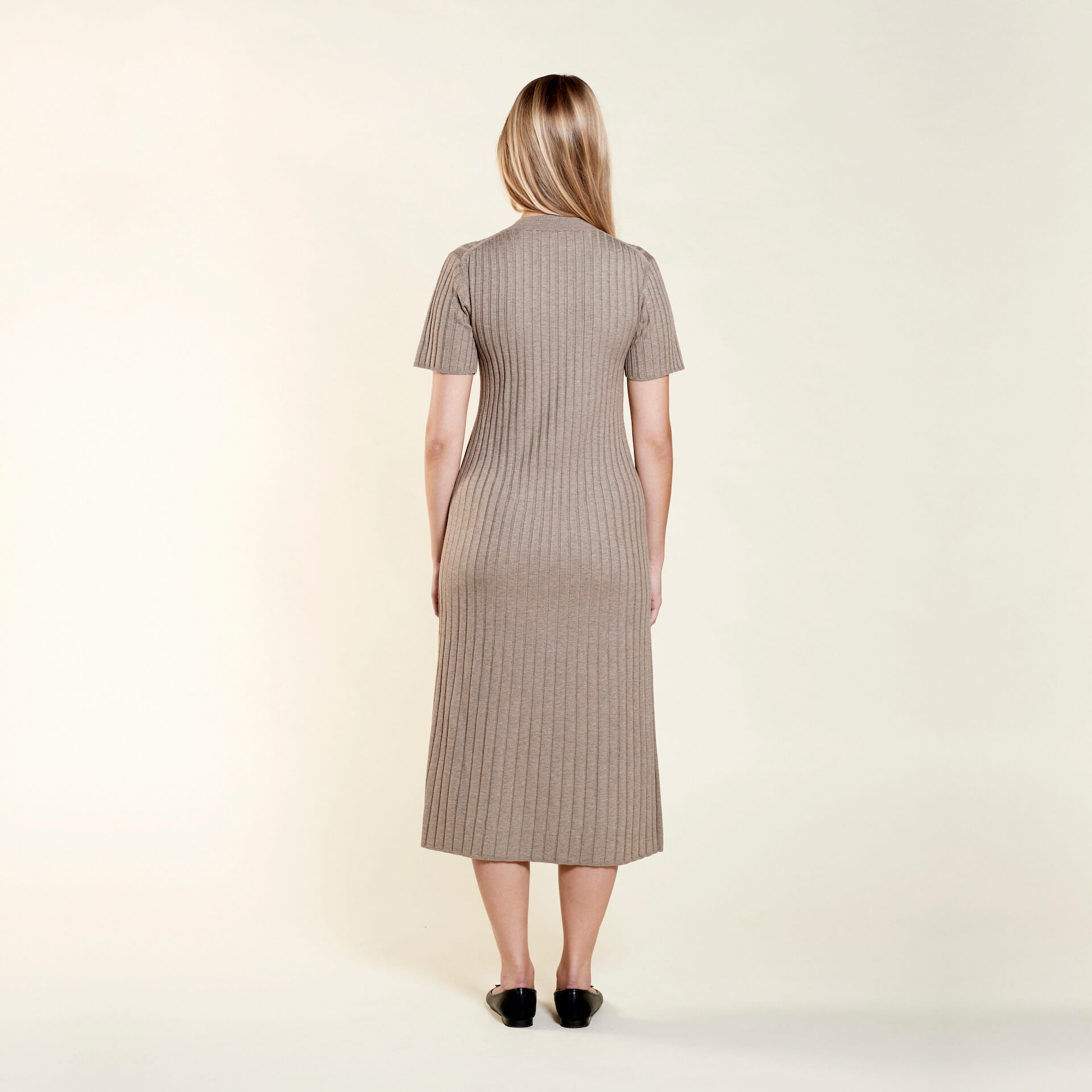 Back view of a timeless ribbed taupe knit dress by Cyme Copenhagen, illustrating the elegance of Scandinavian design with a focus on sustainable fashion and natural materials.