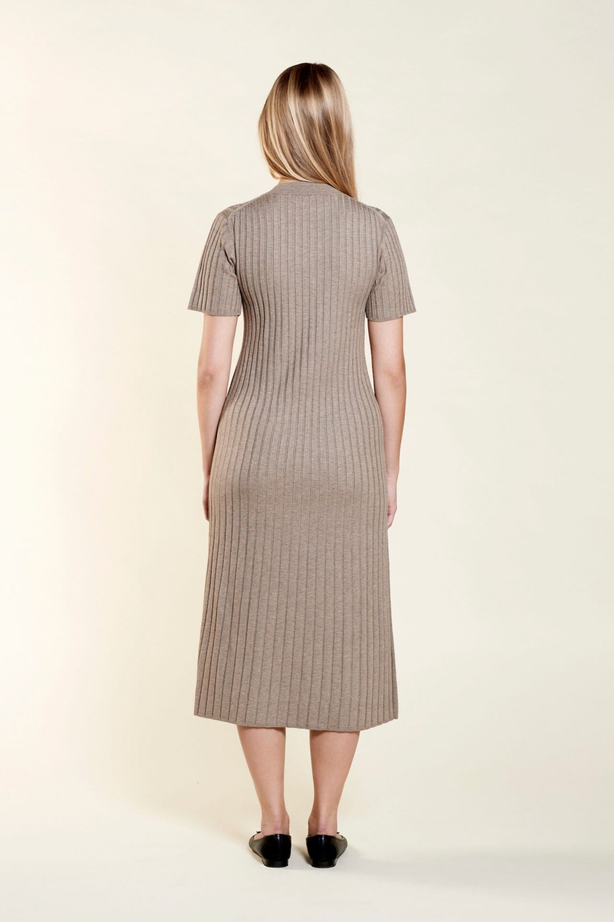 Back view of a timeless ribbed taupe knit dress by Cyme Copenhagen, illustrating the elegance of Scandinavian design with a focus on sustainable fashion and natural materials.