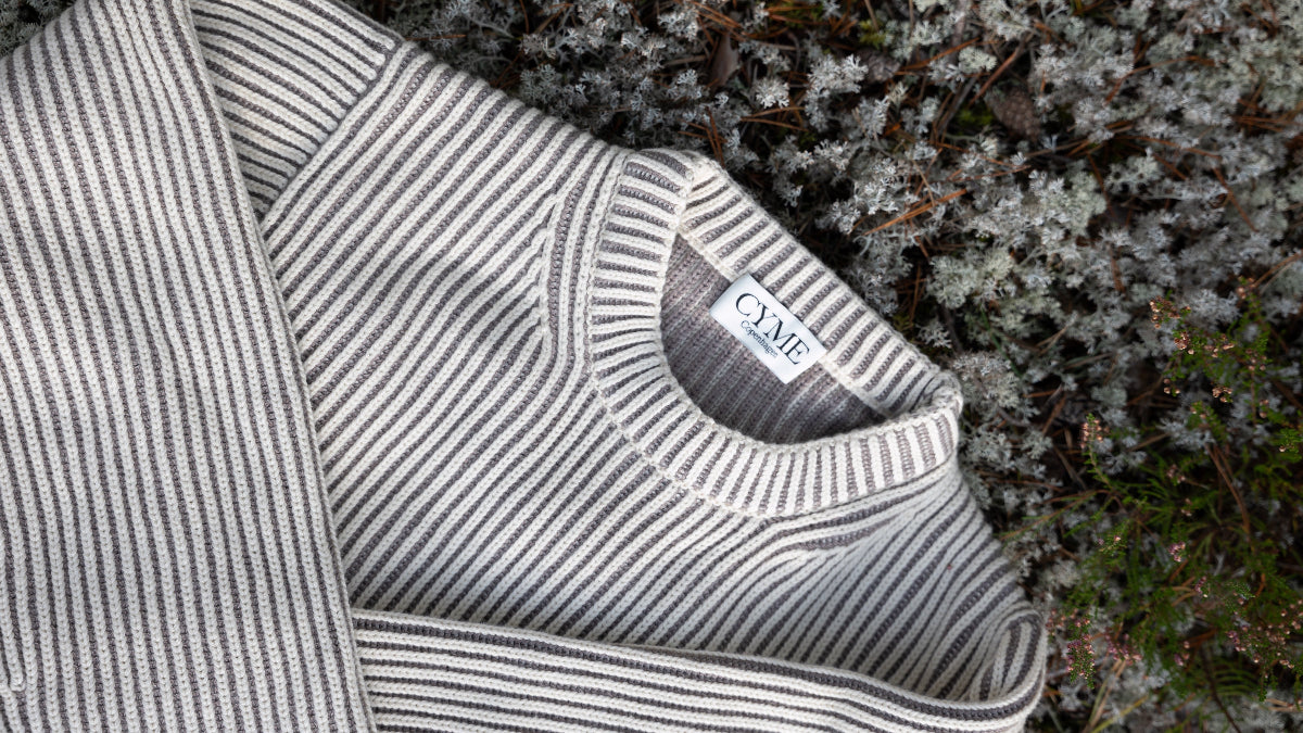 Striped sweater with a brand label on a natural background
