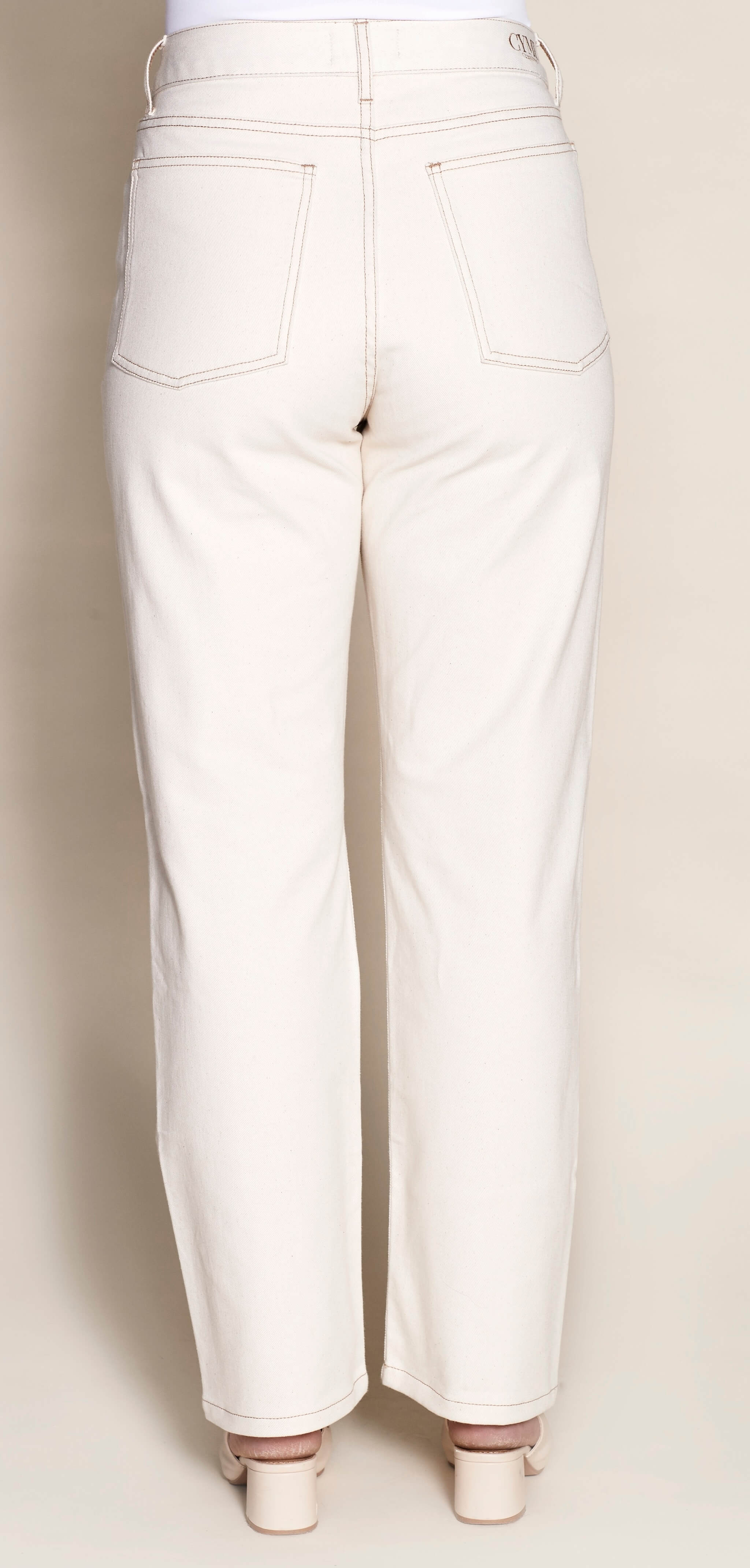 Rear view of Cyme Copenhagen's cream denim trousers, featuring a clean and classic design with signature branding on the waistband, showcasing the sustainable and chic Danish fashion ethos.