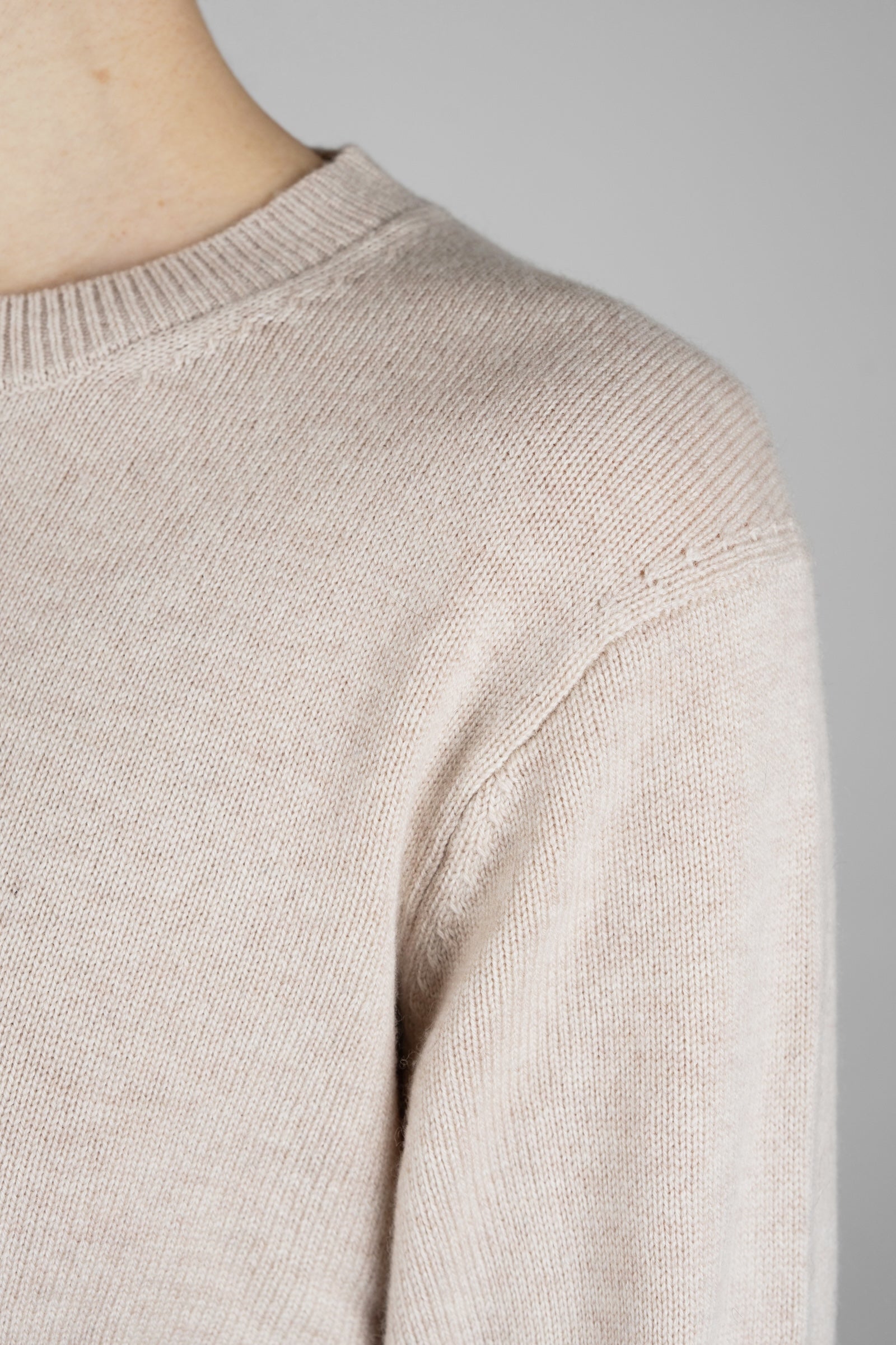 Close-up of a beige sweater on a neutral background