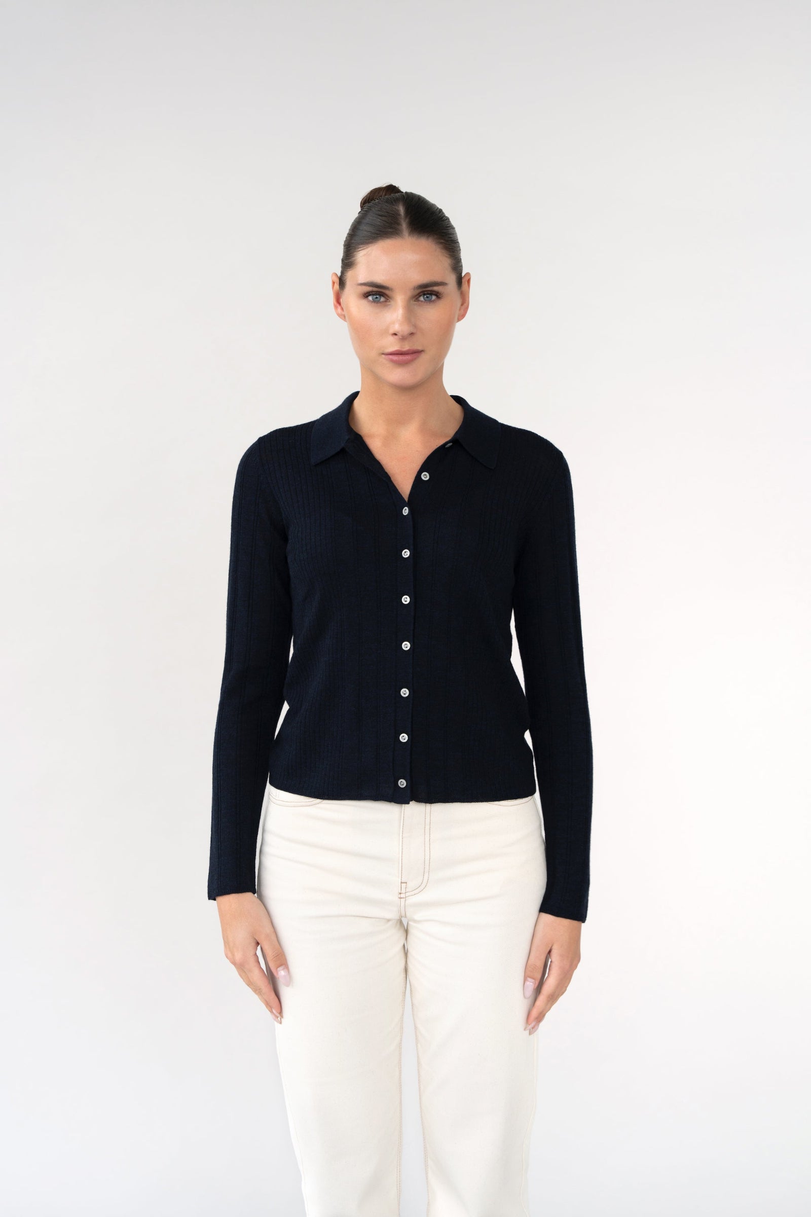 On-model front view of ribbed knit cardigan with shirt collar, navy, buttoned front, studio.