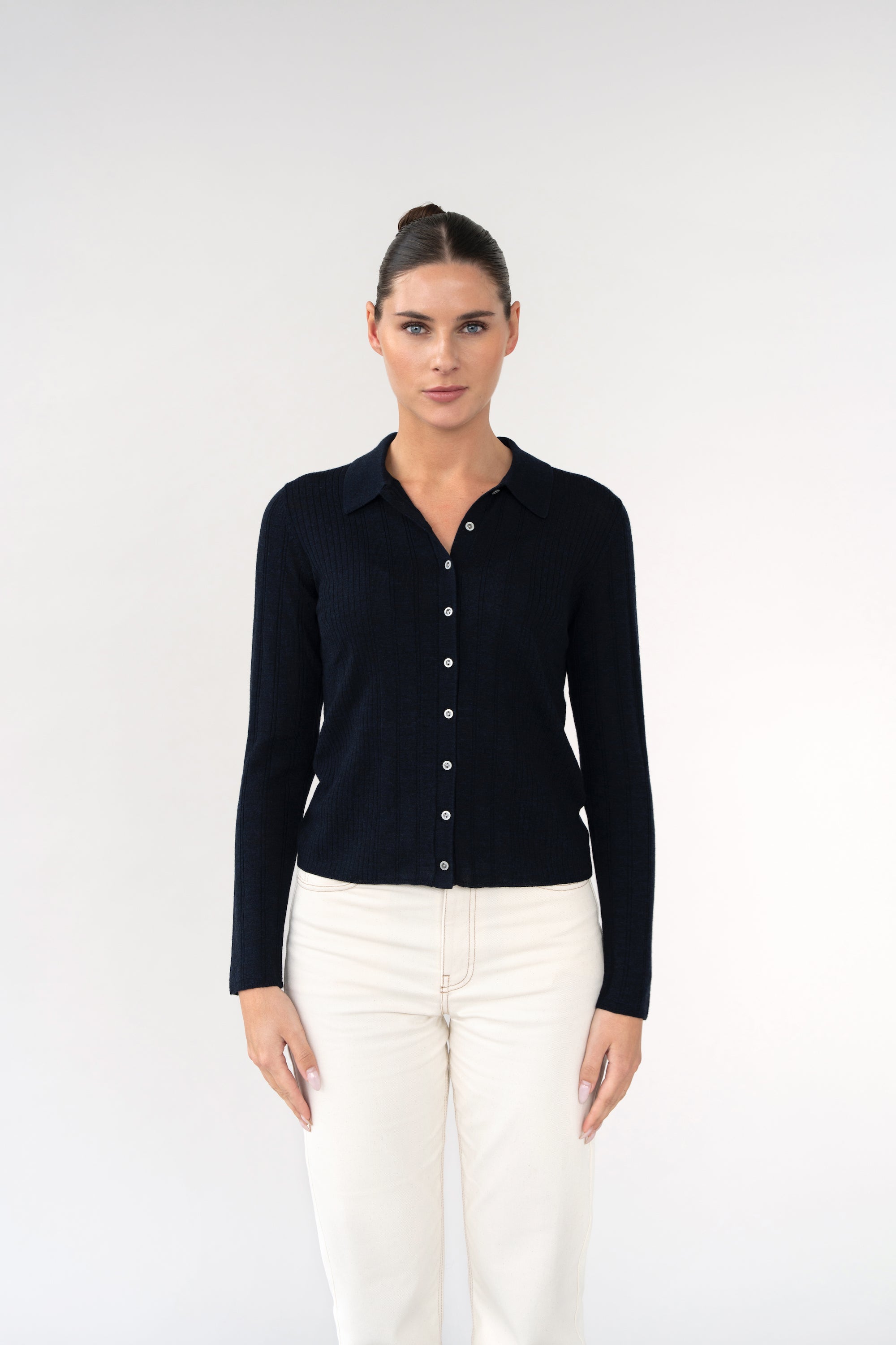 On-model front view of ribbed knit cardigan with shirt collar, navy, buttoned front, studio.