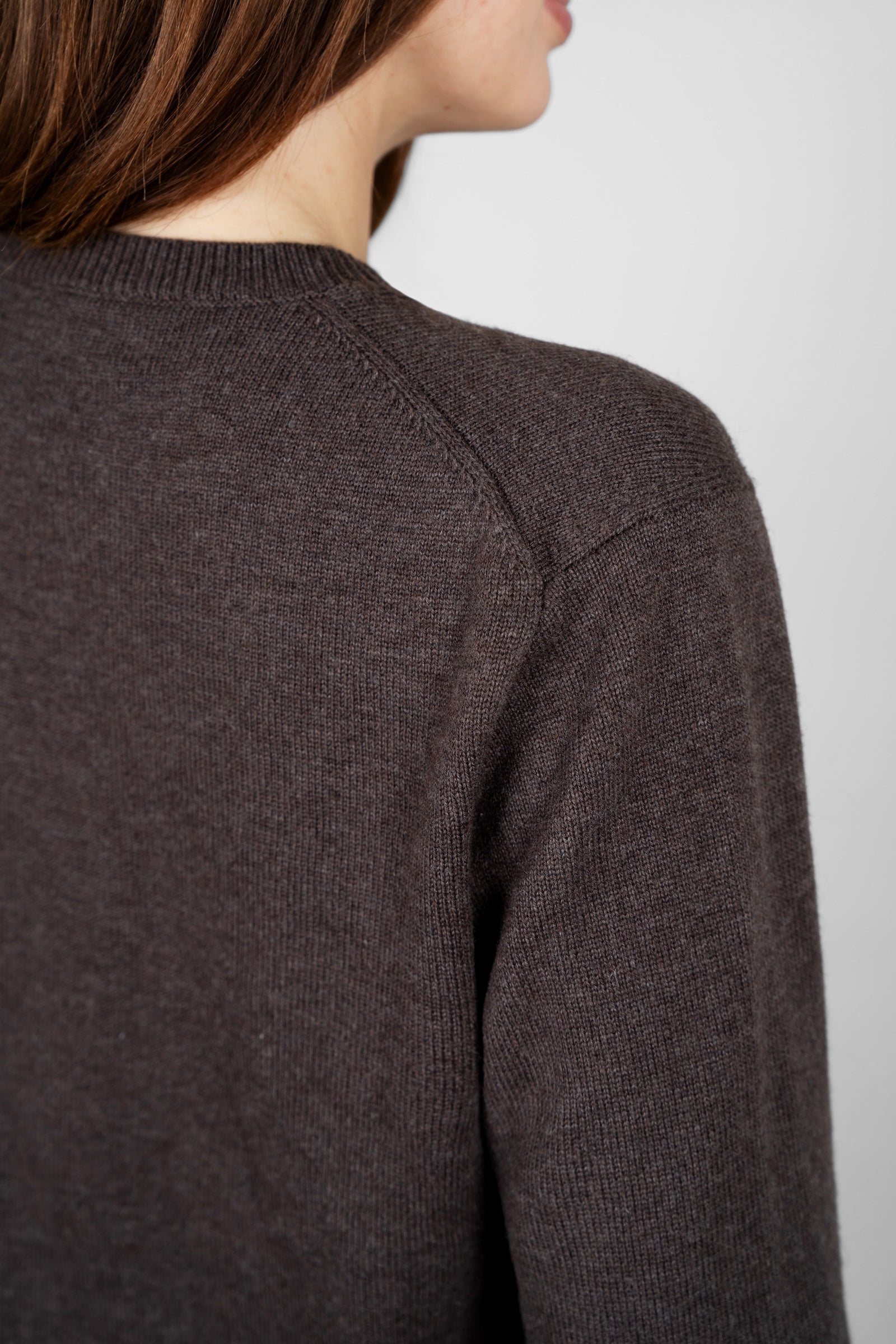 Close-up detail of the CYME Cashmere-Merino Crewneck Jumper in dark brown, highlighting the ribbed crew neckline and shoulder seam. The cashmere-merino blend gives a soft, warm finish.