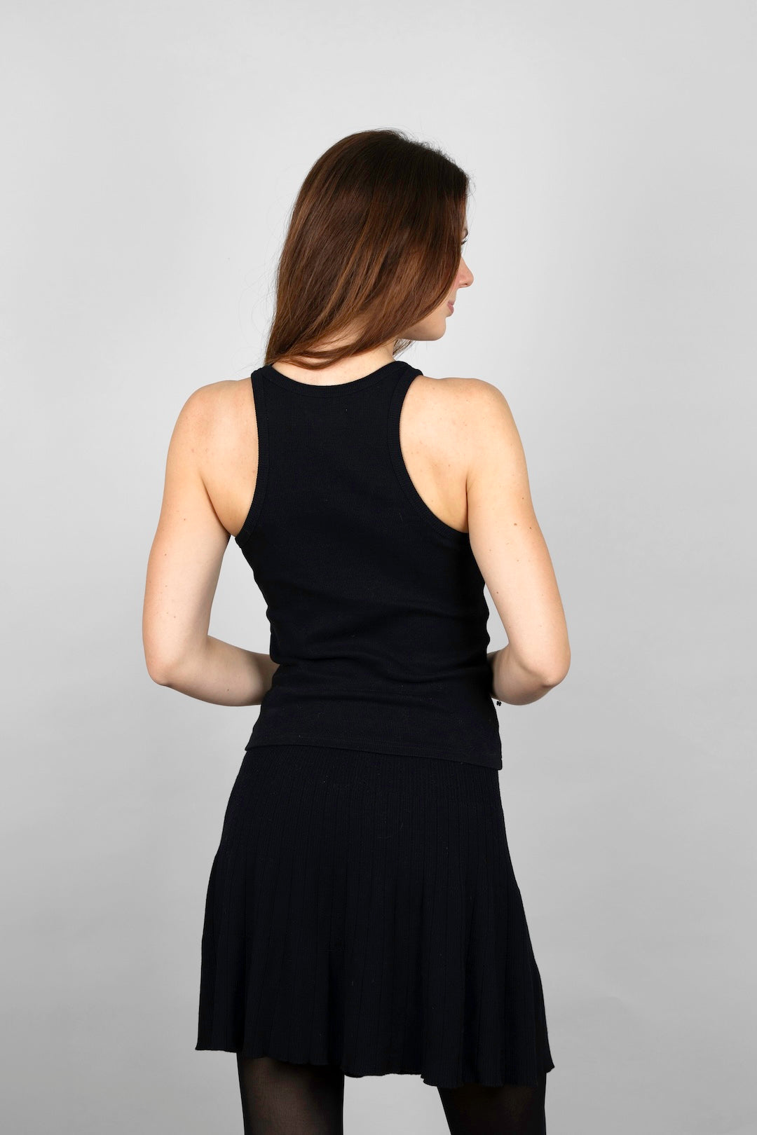Back view of the CYME tank top in black, showing the clean racer-back cut in a fine ribbed knit. Crafted in breathable organic cotton for a timeless, easy fit.