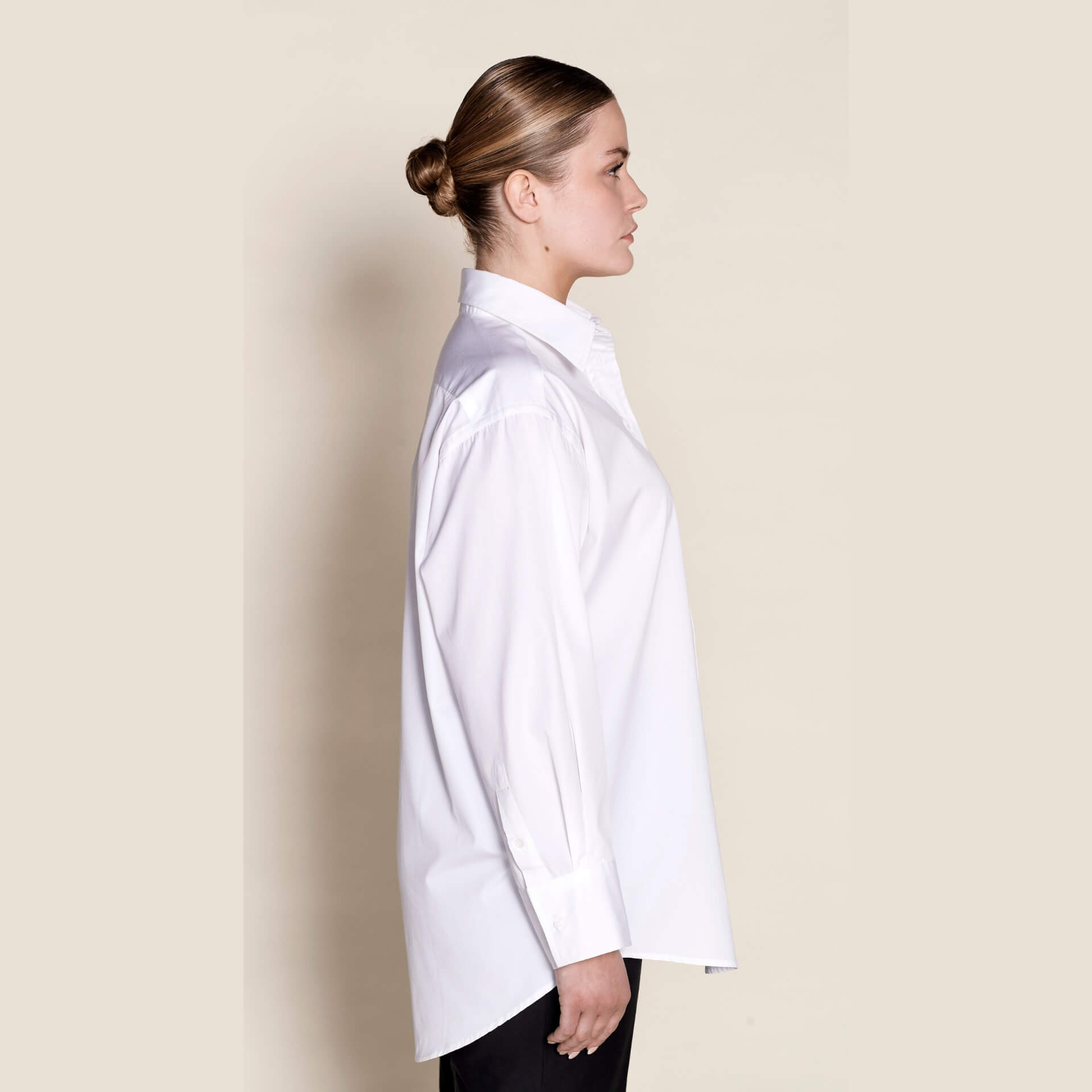 Side profile of a Cyme Copenhagen classic white shirt, displaying the relaxed fit and elegant tailoring that make it a timeless wardrobe essential for sustainable Scandinavian style.