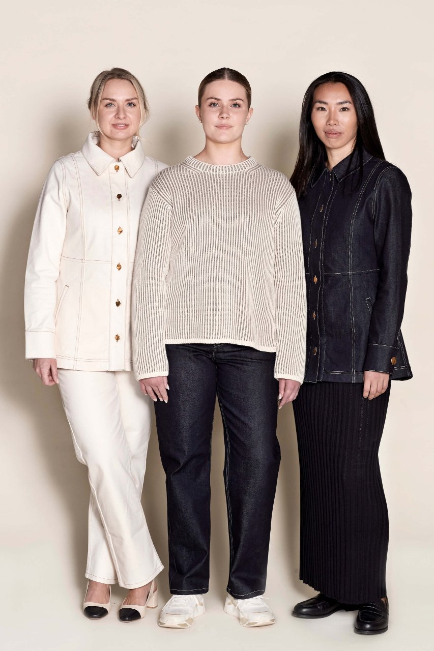 Three diverse models showcasing Cyme Copenhagen's latest collection, featuring a classic white buttoned denim jacket, a cream ribbed knit sweater, and a sleek dark denim suit, embodying timeless Scandinavian fashion and sustainable design with natural materials.