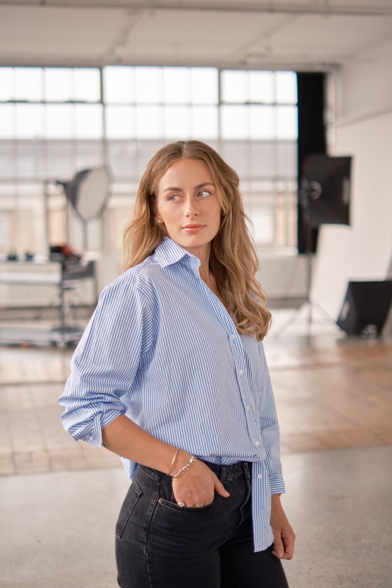 Woman wearing a blue checkered shirt in an indoor setting