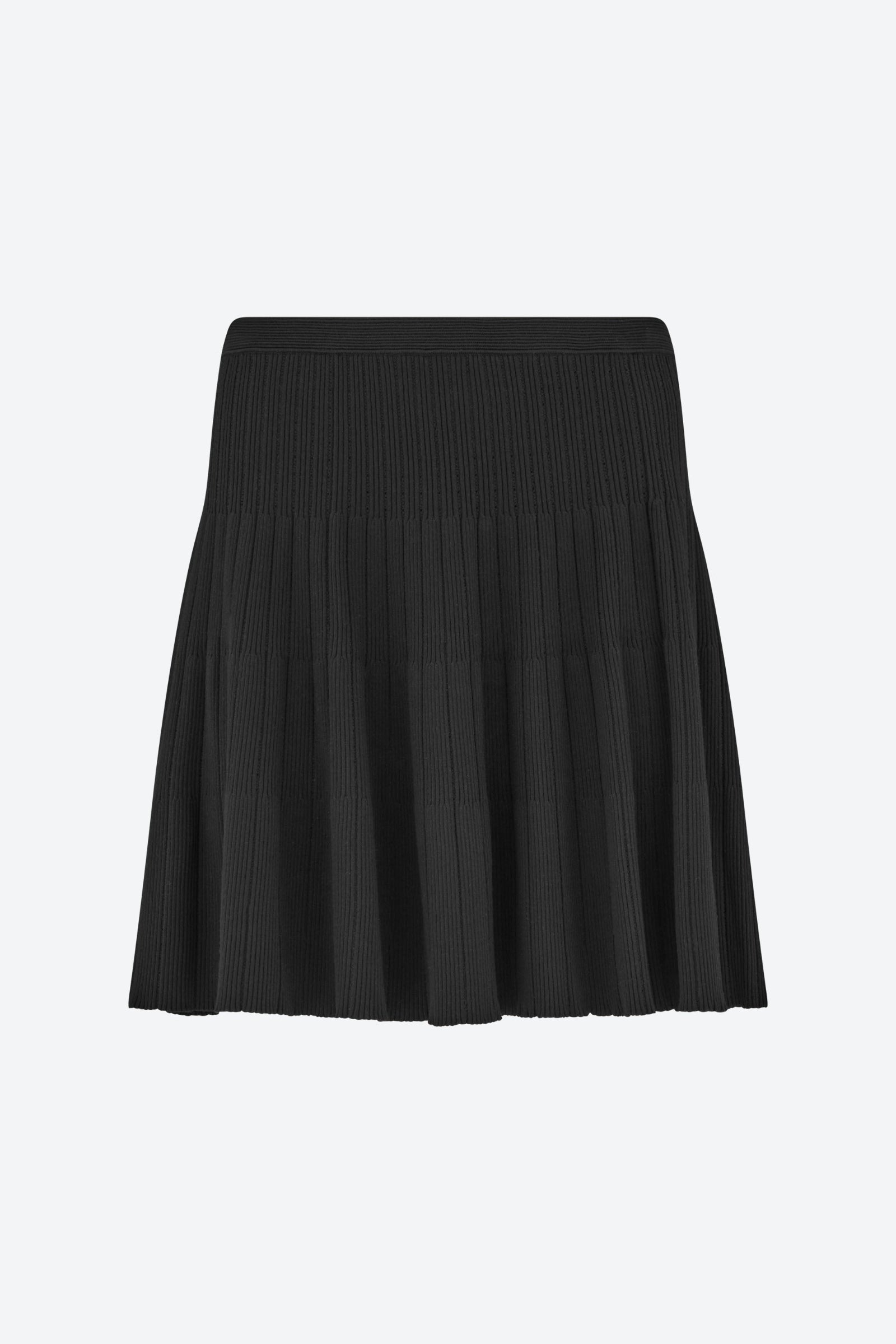 Front view of the CYME Knit Skirt in black. A softly structured ribbed knit skirt featuring a wide waistband and fluid pleating—offering effortless elegance and comfort.