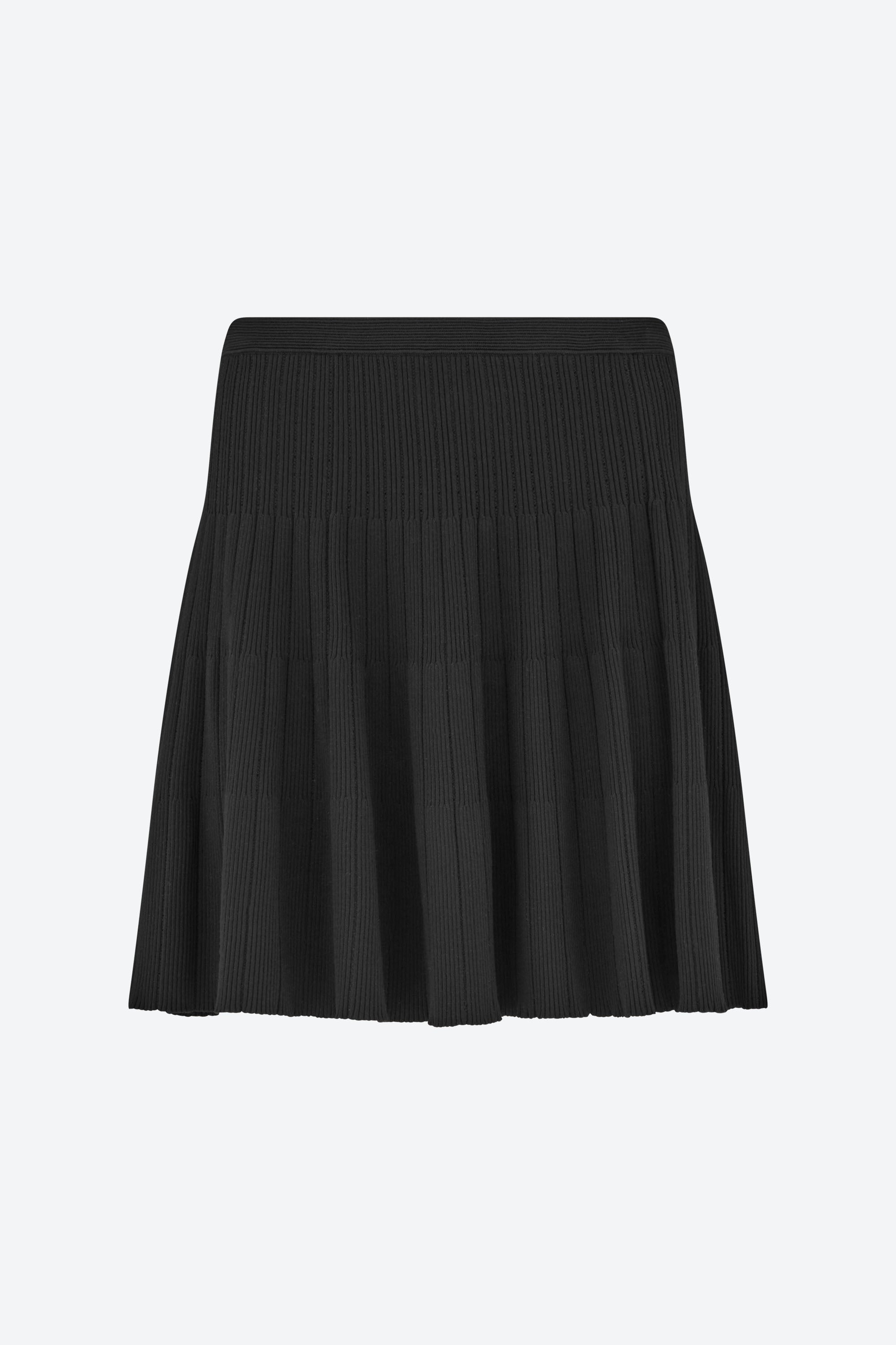 Front view of the CYME Knit Skirt in black. A softly structured ribbed knit skirt featuring a wide waistband and fluid pleating—offering effortless elegance and comfort.